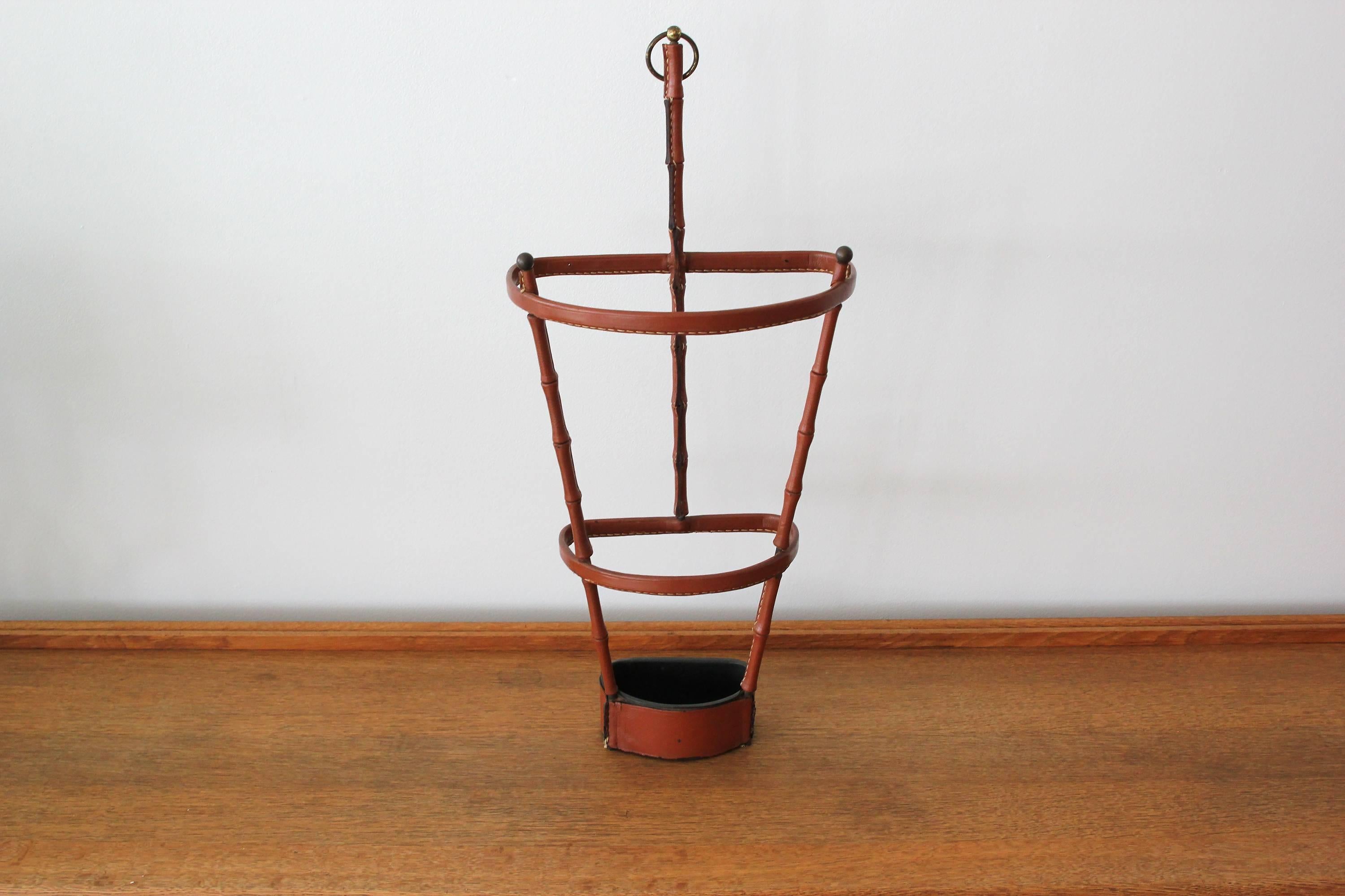 Handsome leather umbrella stand by Jacques Adnet. Saddle leather has signature Adnet contrast stitching and beautiful patina. Inset iron dish at the base to collect water. Excellent vintage condition. Very rare piece.