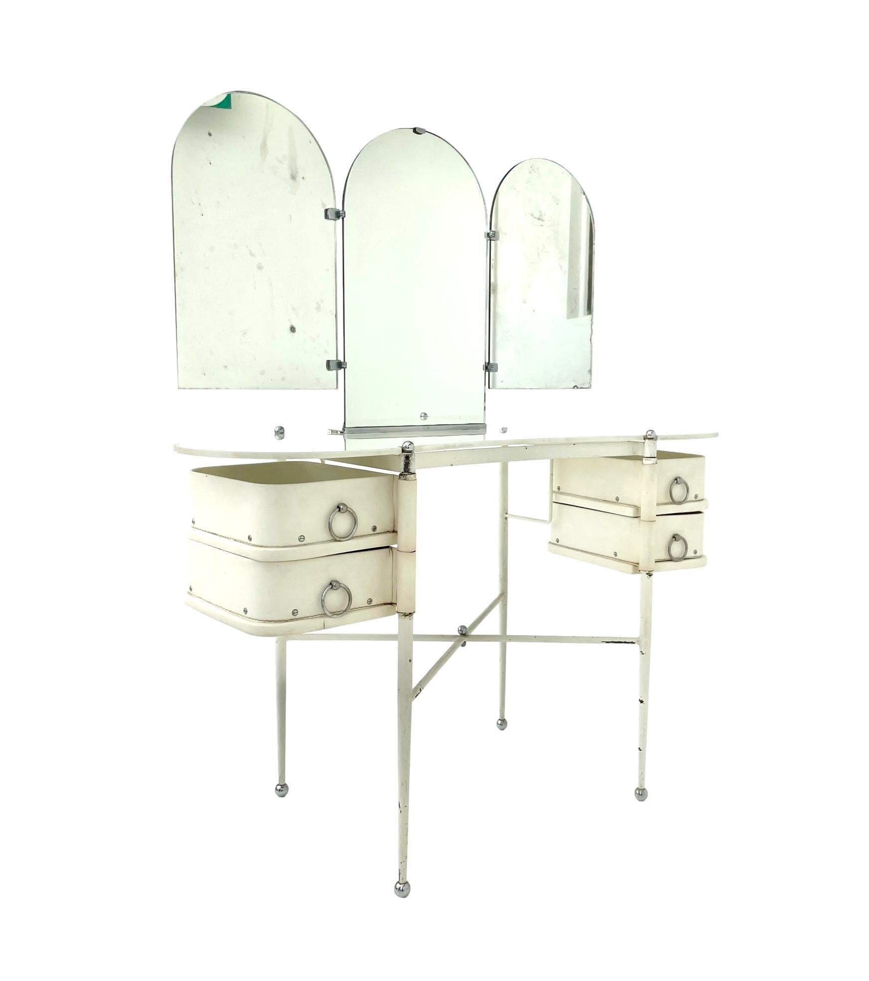 Monumental vanity by French designer Jacques Adnet. Metal frame with chrome ball feet. 2 drawers flank each side and swivel 180 degrees. Opaque glass kidney top. Triptych mirror with antique glass. Both side mirrors rotate in and out 90 degrees.