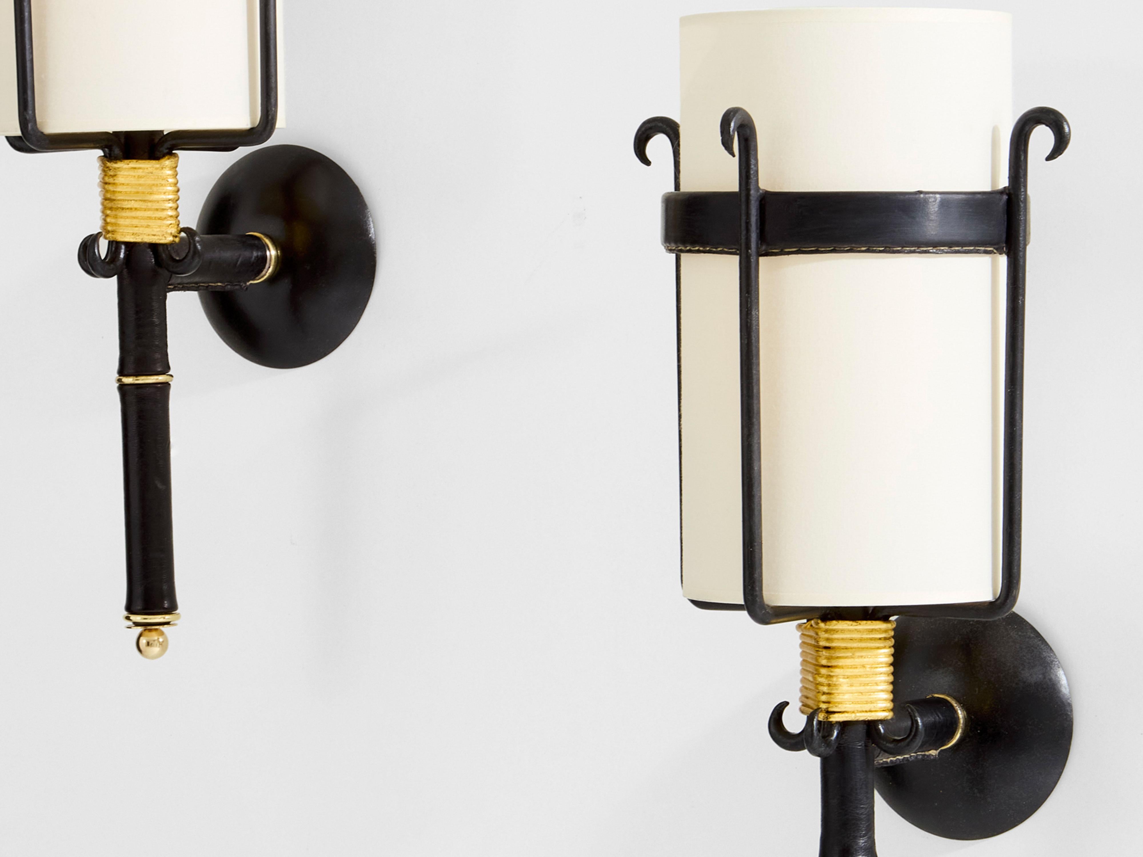 Beautiful pair of sconces in wrought iron and black leather piqué sellier by Jacques Adnet dating from the early 1950s. These wall lights are characteristic of Adnet's work, soft saddle-stitched leather, dit piqué sellier, and visible wrought iron