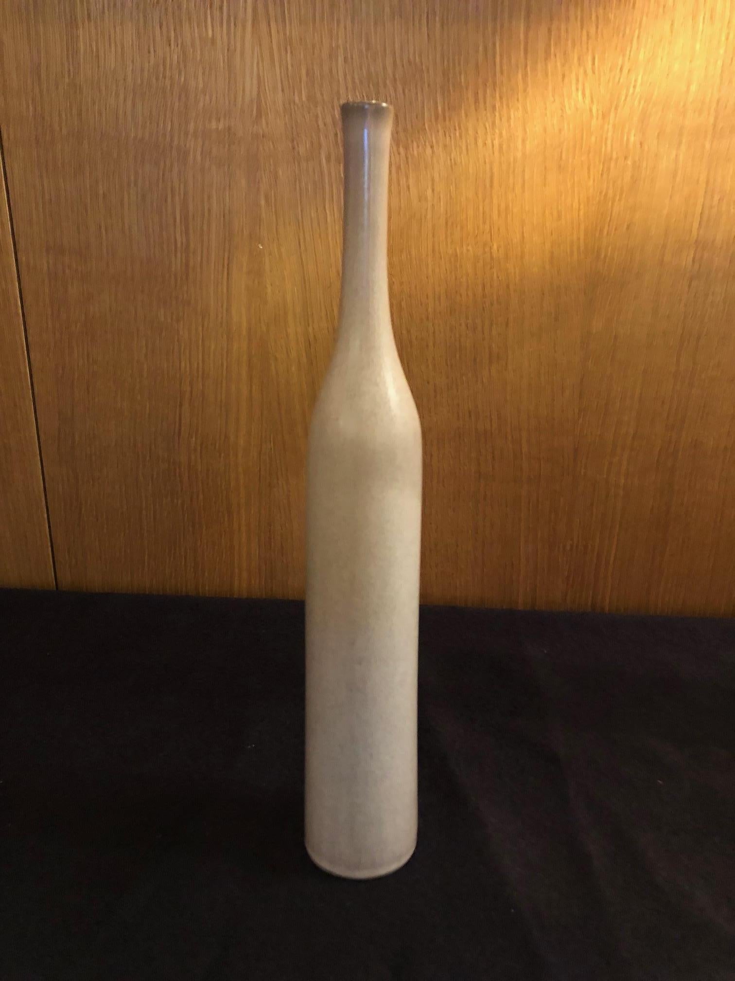 A bottle form vase by the French ceramic artists Jacques and Dani Ruelland. A mottled pinkish / white-grey glaze.