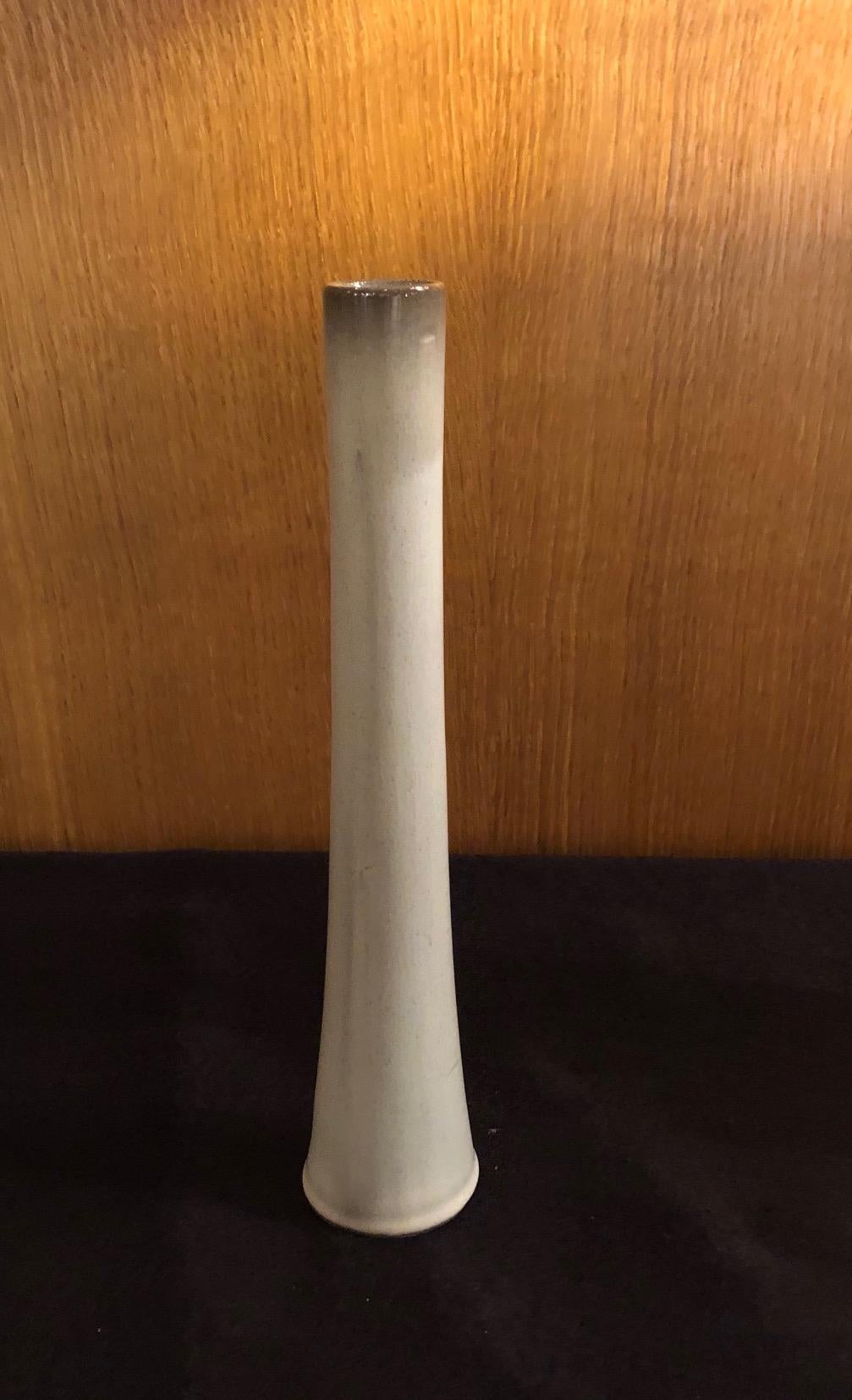 Un vase en forme de roseau réalisé par les artistes céramistes français Jacques et Dani Ruelland. Une glaçure blanche et grise.