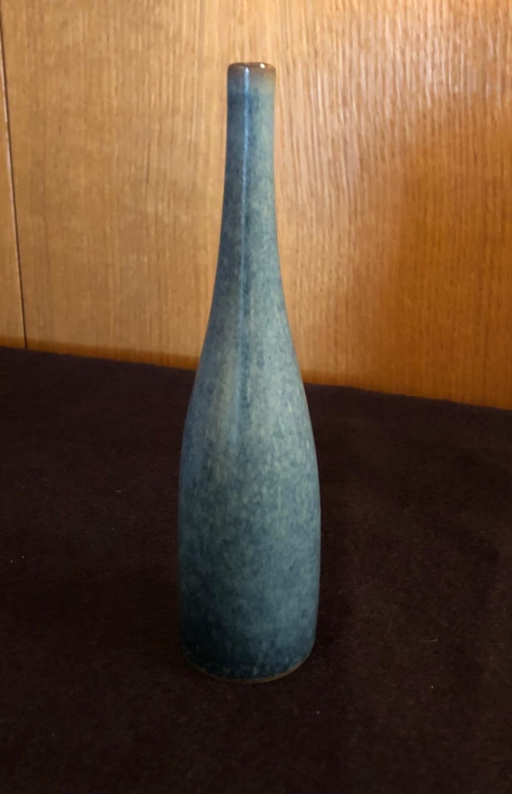 A small bottle form vase by the French ceramic artists Jacques and Dani Ruelland. A heather blue glaze, black interior. Signed.