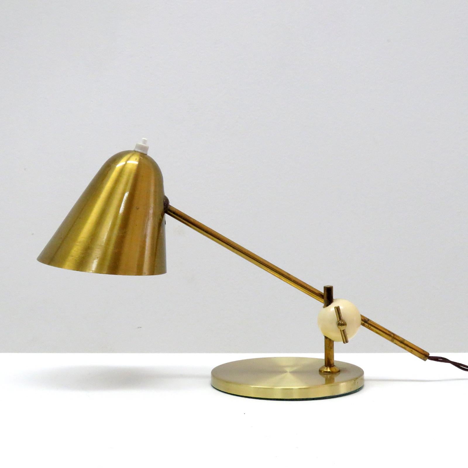 Wonderful brass table lamp by Jacques Biny with wonderful patina, adjustable at the hood and the white bakelite ball joint, wired for US standards, one E12 socket per fixture, max. wattage 60w or LED equivalent, bulb provided as a onetime courtesy.