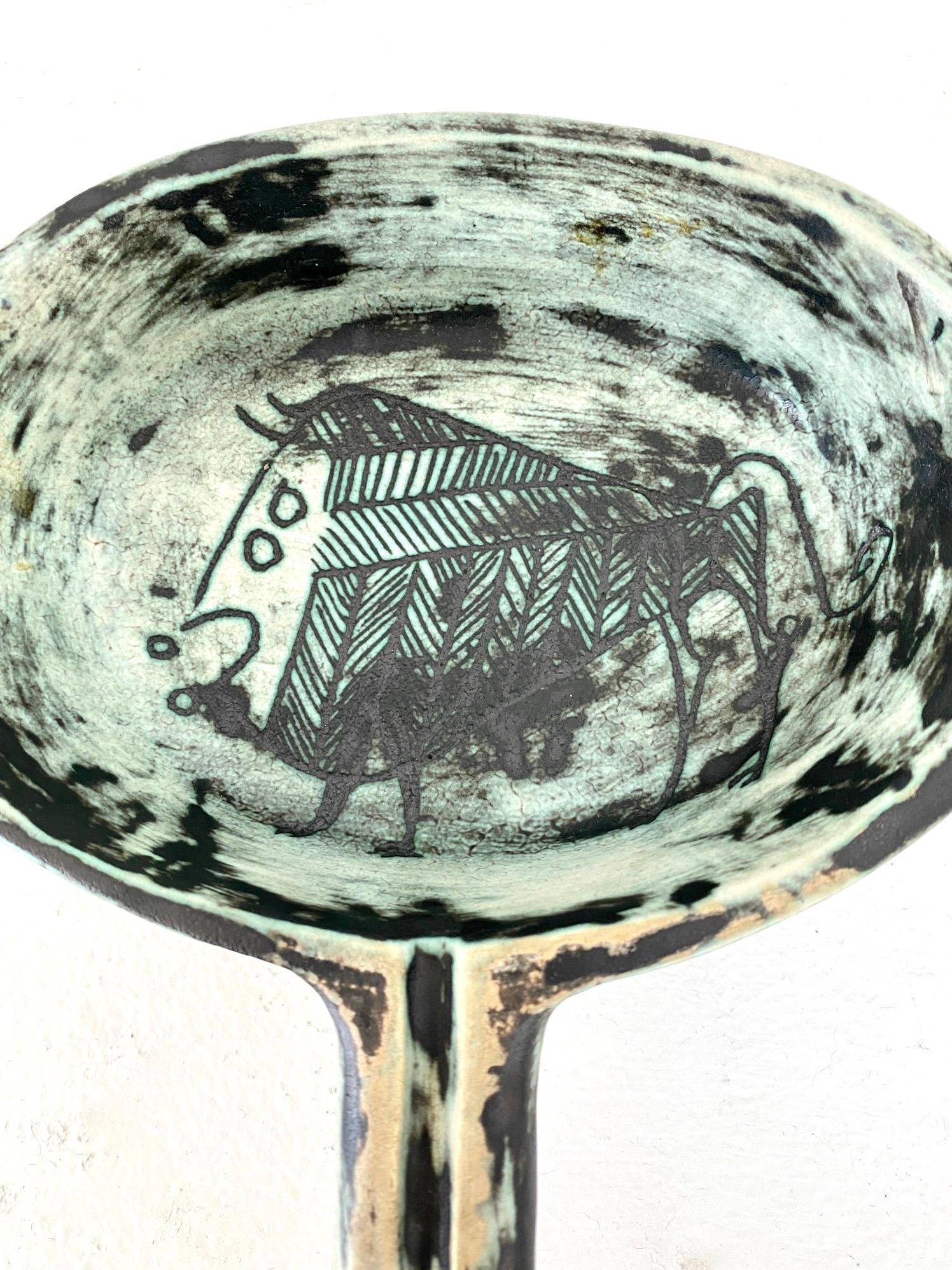 A French ceramic vide poche or small handled bowl by noted French ceramic artist Jacques Blin.
The iconic image of a bull or toro is expressed in Blin's wonderful scrafitto markings. This bowl or dish or vide poche is in the paler blue color with
