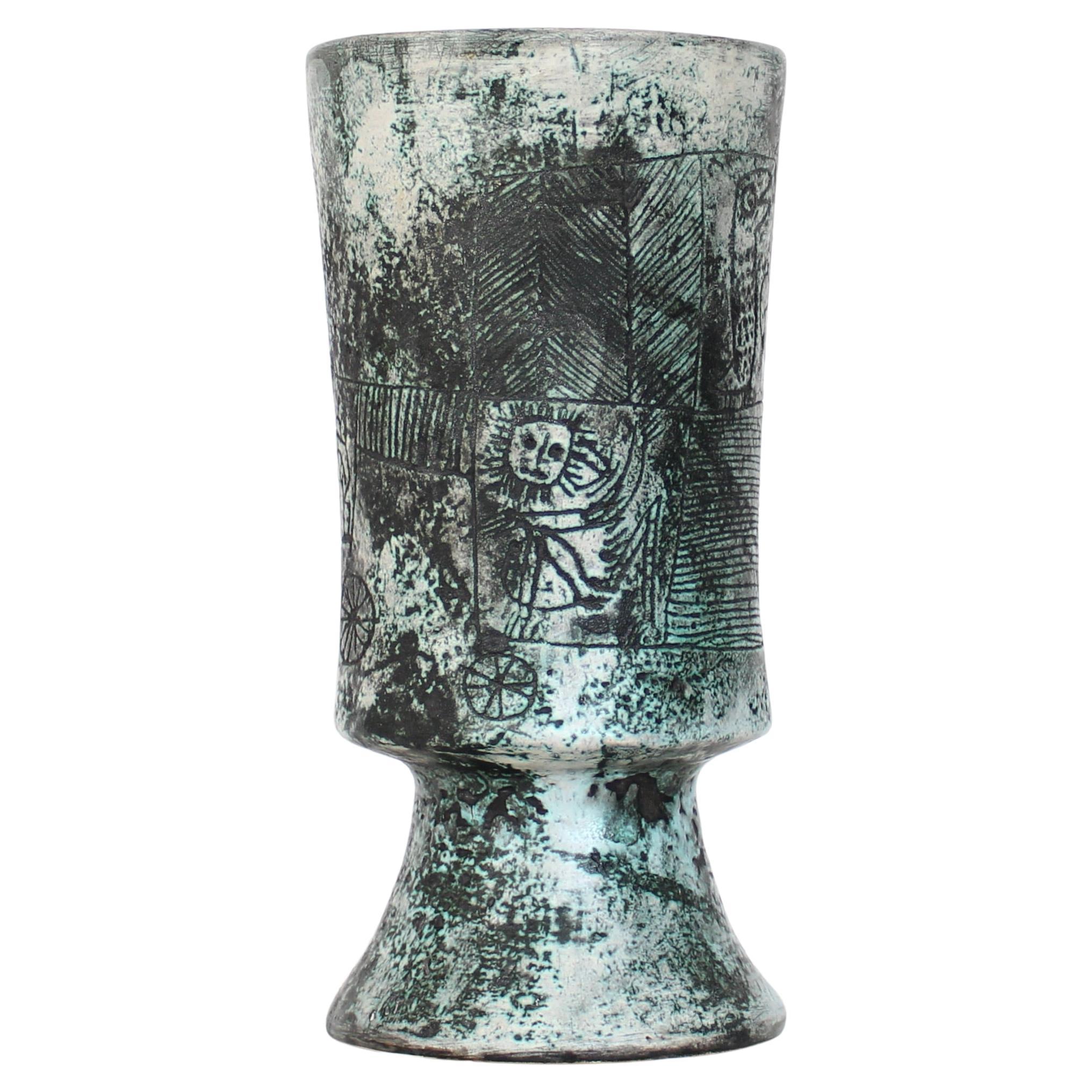 Jacques Blin türkisblau glasiert mit ikonischen Sgraffito-Zeichnungen hohe Kelchvase. Ikonische Sgraffitogravur am Hals und am Boden mit Linien und Kreisen in Bändern. Innen cremefarben glasiert.
Die Zeichnungen sind von Tieren und Kreaturen. Viele