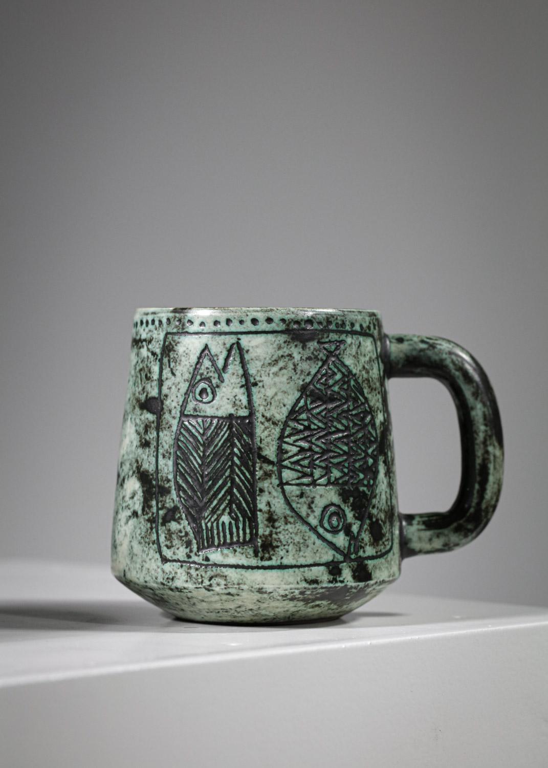 Duo de mugs en céramique de l'artiste français Jacques Blin des années 60. Émaillage dans les tons verts avec des dessins sur chacune des tasses représentant des animaux stylisés aux formes géométriques typiques de l'œuvre de l'artiste. Très bel
