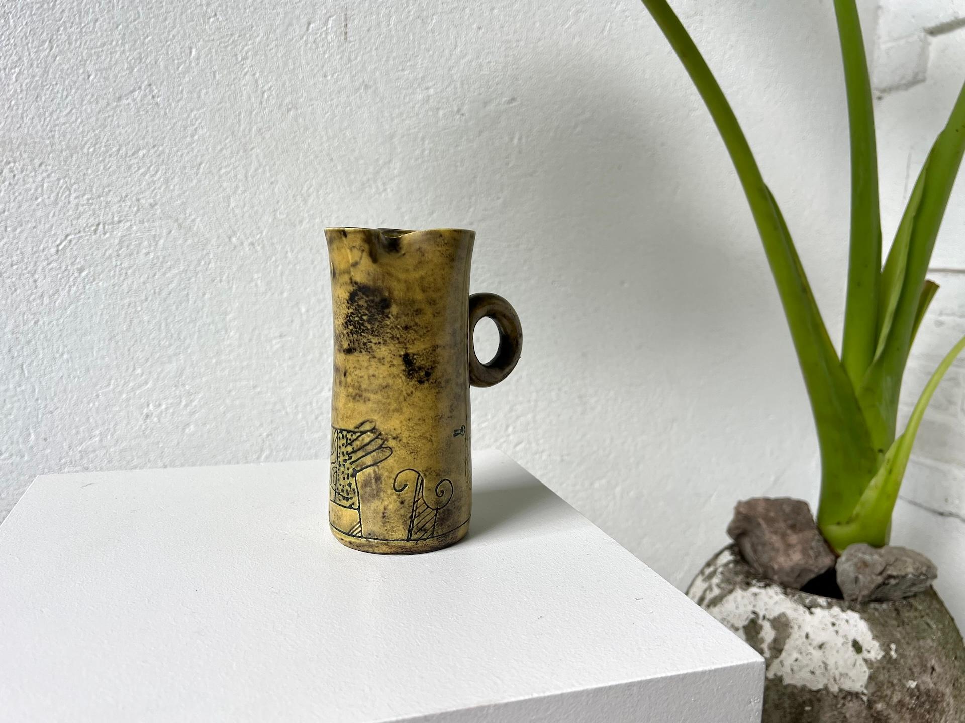 This ceramic vase or pitcher by Jacques Blin, yellow in color, rather rare in the work of Jacques Blin, presents pretty incised decorations. 

The falsely naive motifs of fantastic animals, deeply incised in the ceramic, refer to his attraction to