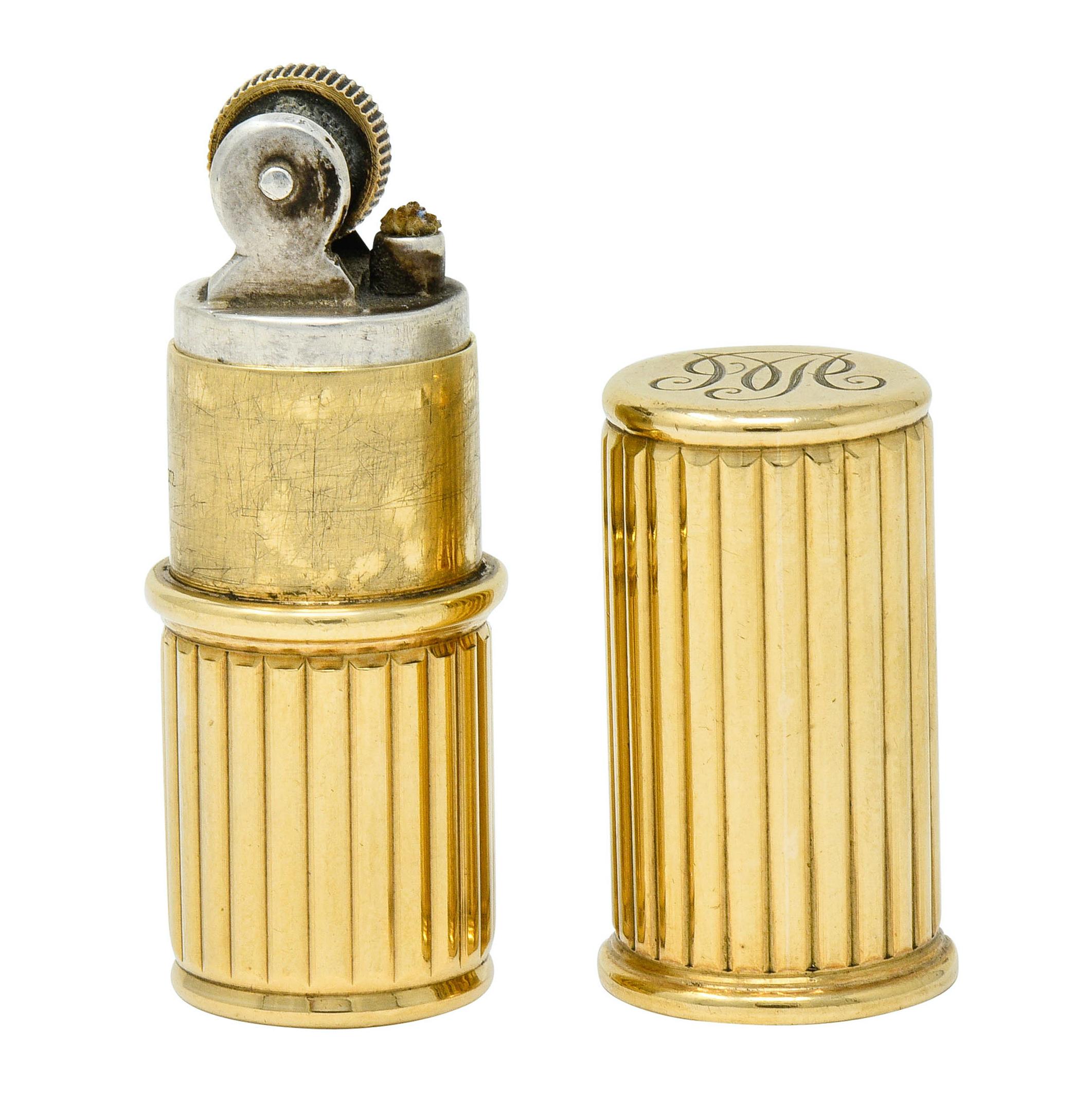 Designed as a sleek tubular form comprised of deeply ribbed polished gold

Cap slides off to reveal a lighter with functional flint wheel and remains of a wick

Numbered and fully signed Cartier London with monogrammed base

With maker's mark for