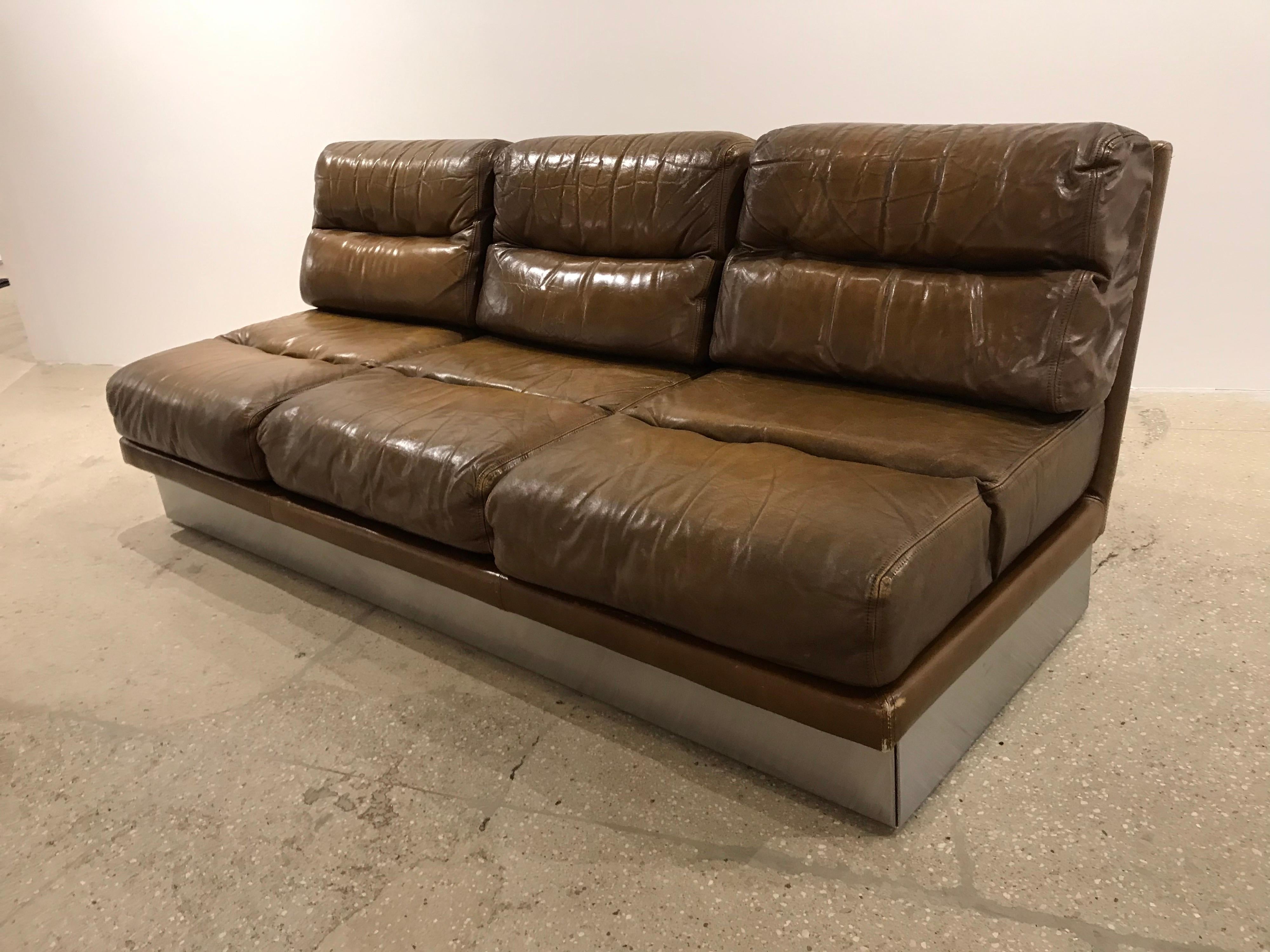 A three-seat leather and stainless steel French sofa by Jacques Charpentier. A matching pair of lounge chairs available.