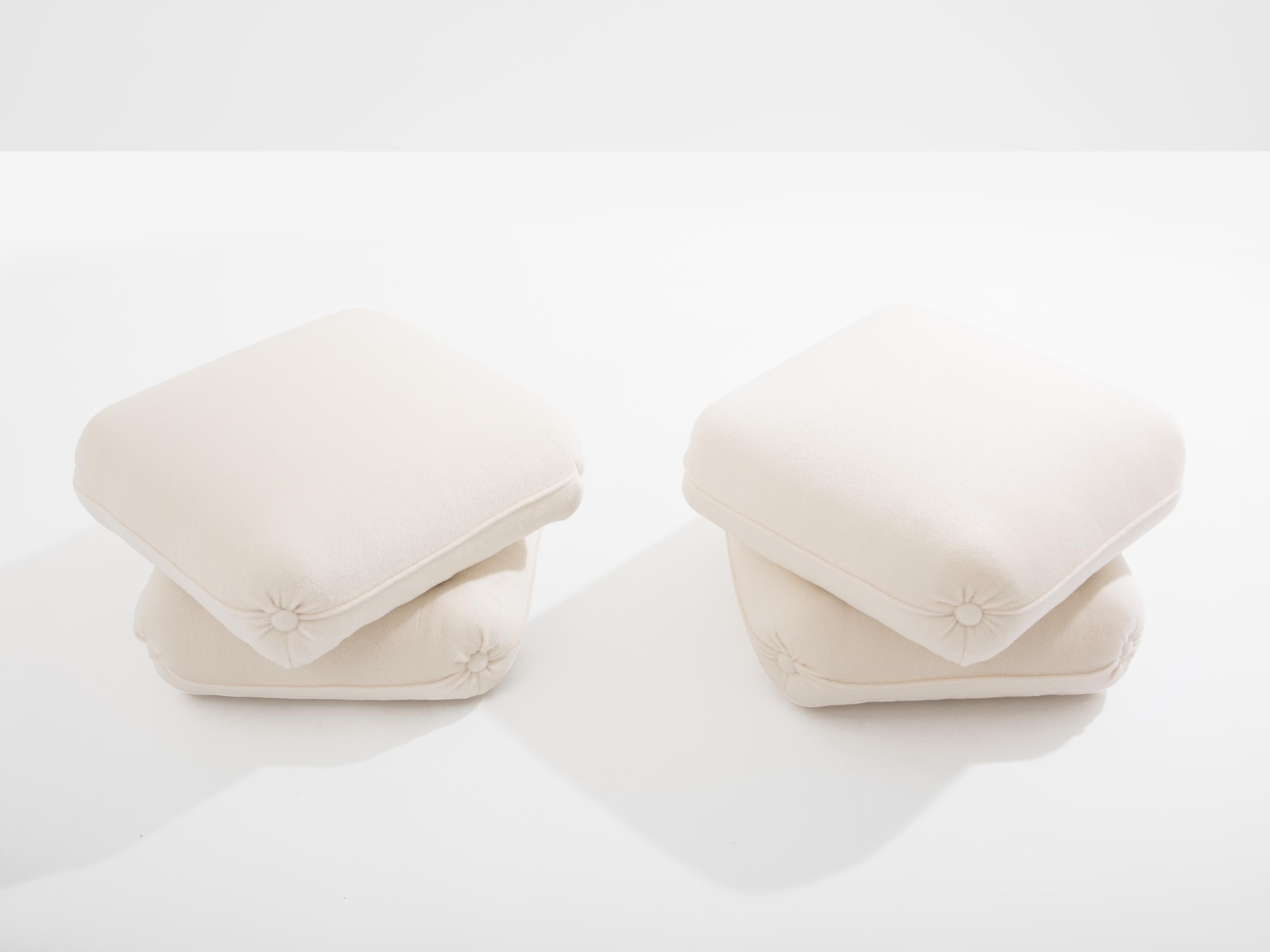 Paire de poufs conçus à la fin des années 1970 par Jacques Charpentier pour la Maison/One. La paire de poufs est composée de deux grands coussins reliés entre eux. Ils ont été récemment recouverts d'un tissu en laine d'alpaga blanche incroyablement