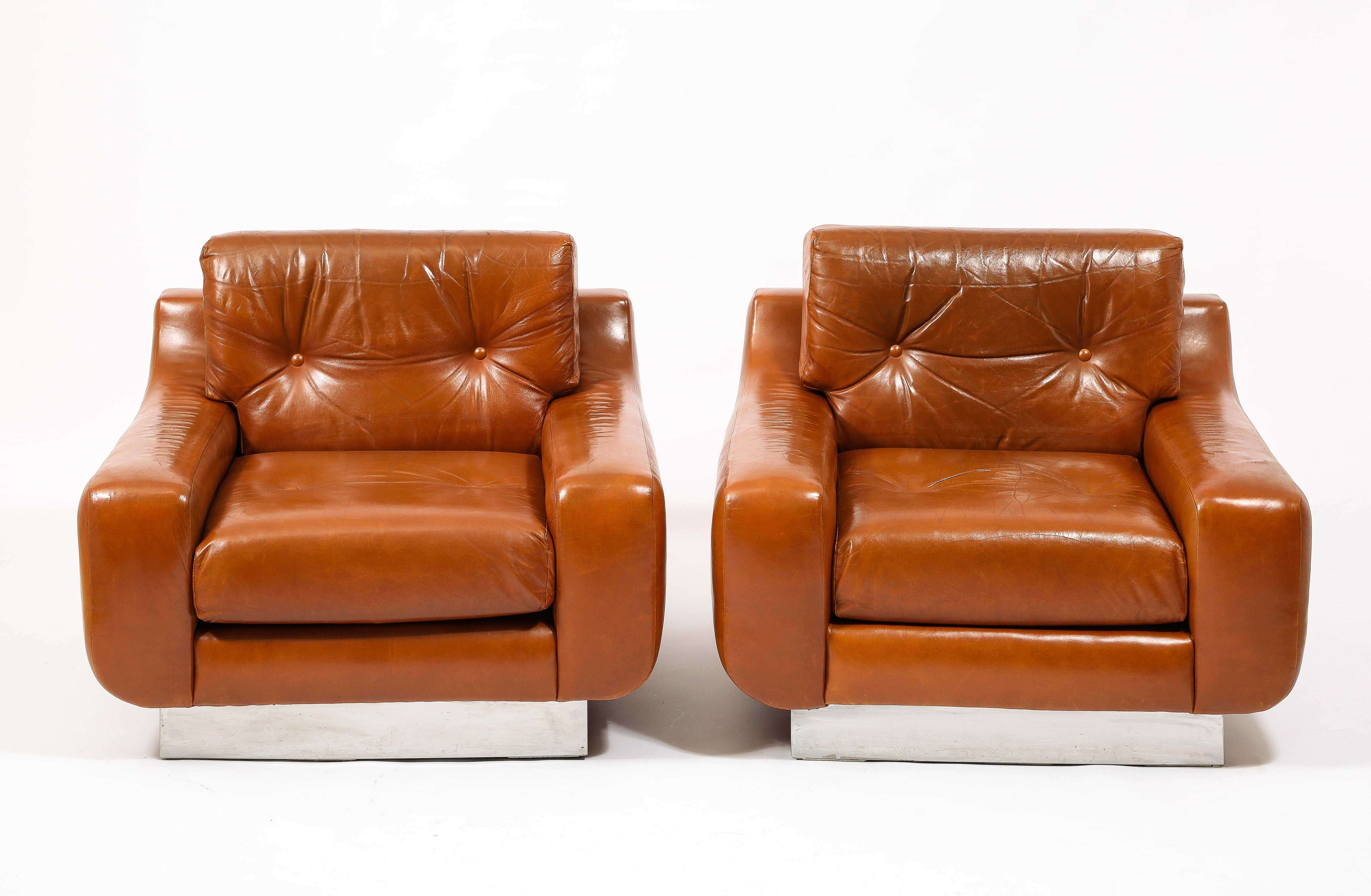 A rare pair of Jacques Charpentier armchairs in original leather preserved by MHG Studio, Interiors have been replaced and they are ready to use. On stainless steel bases with original tags.
