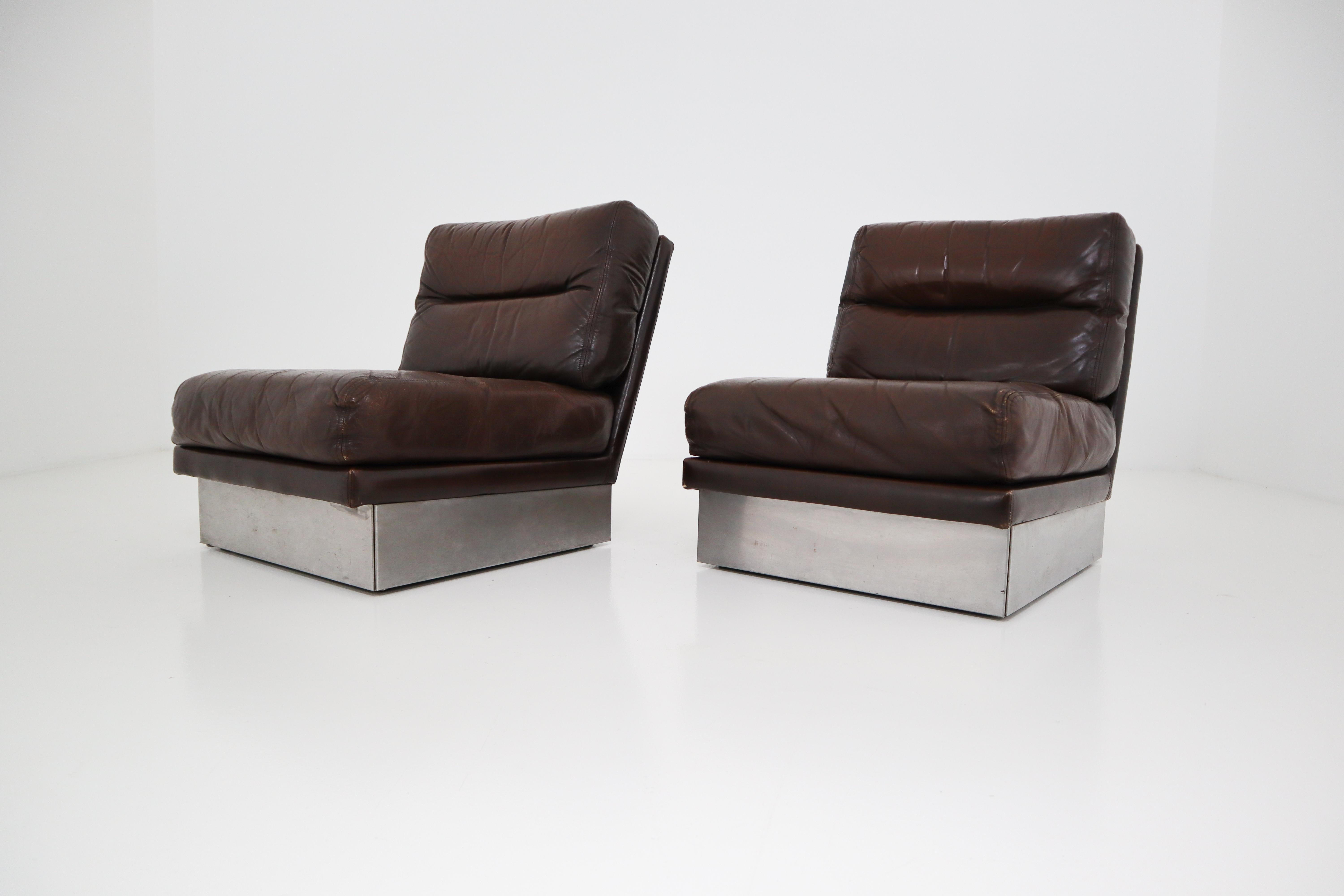 Designed by Jacques Charpentier for Roche Bobois a vintage pair lounge chairs, brown leather, steel base. The high quality leather with a great patina as used on the lounge chairs is phenomenal. These lounge chairs is still in its original condition