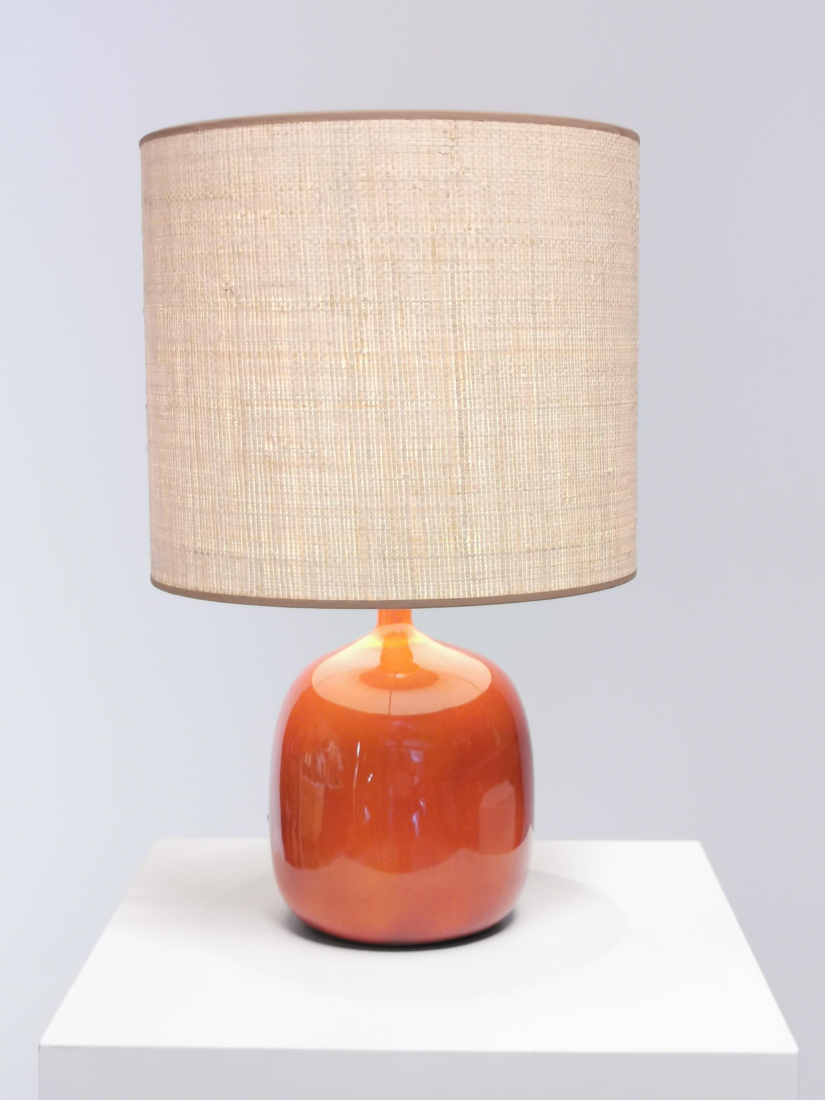 Jacques & Dani Ruelland, orange glazed ceramic lamp and raffia shade.
Executed in their workshop. Underside incised with artist´s signature 