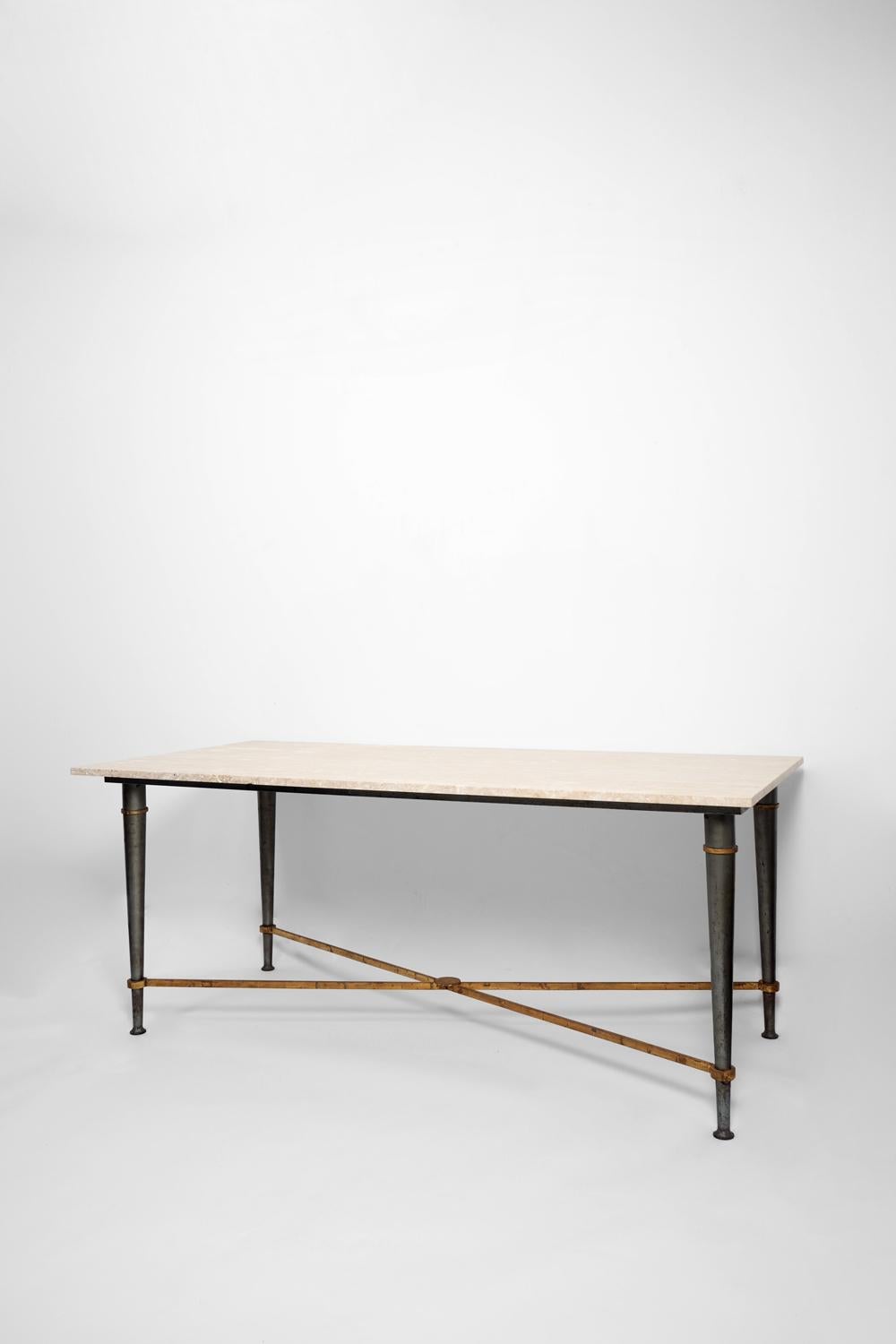Dining table, console, in steel with gunmetal and gilded patinas, with conical ringed legs connected by an X-shaped spacer supporting a beige travertine stone top, by Jacques de Rumigny. France, 1960s.
