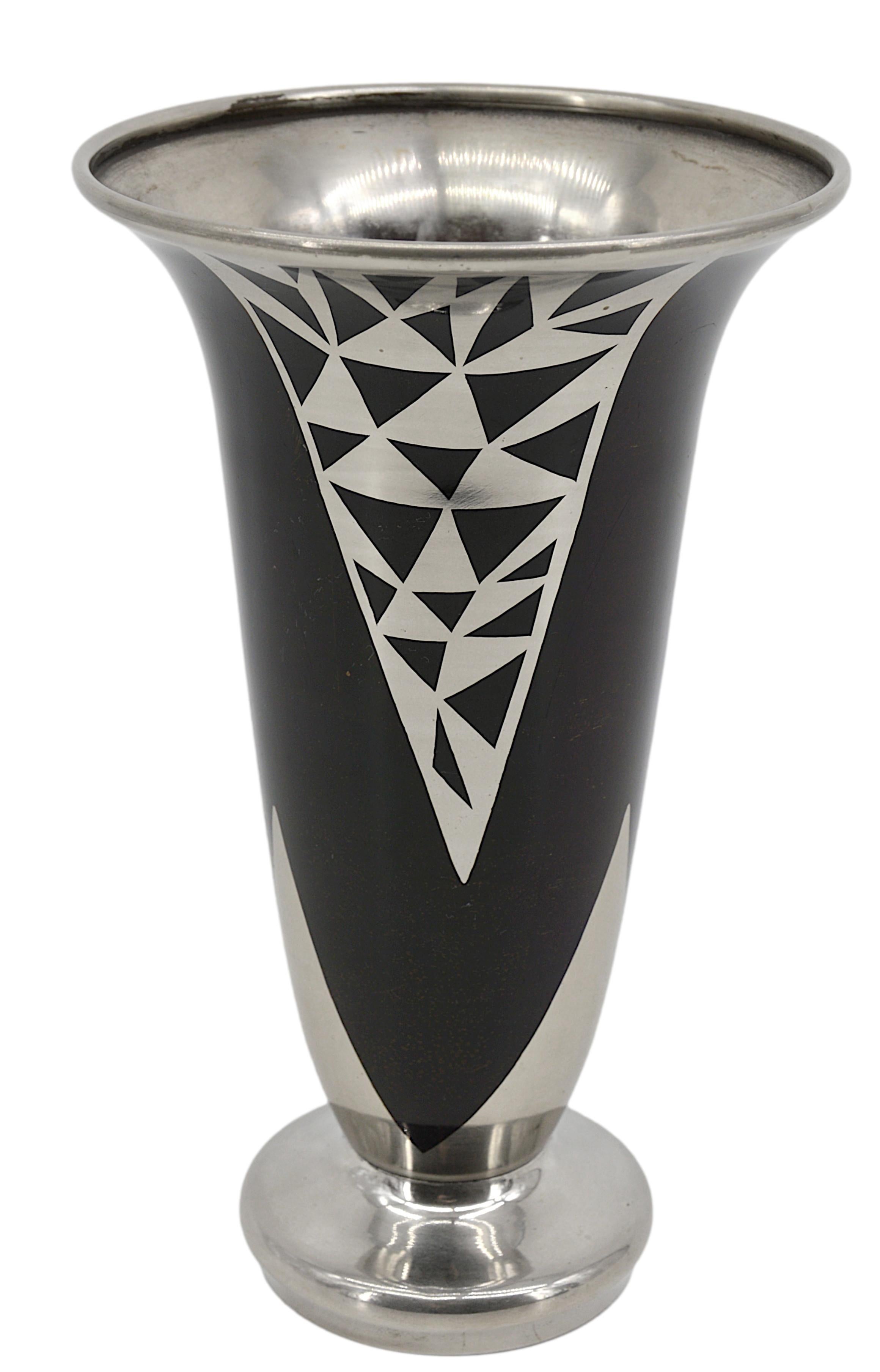 Vaso in ottone Art Déco di Jacques Douau, Francia, 1937 - Design geometrico placcato in argento.

Questo sorprendente vaso in ottone Art Déco di Jacques Douau, realizzato in Francia nel 1937, presenta un raffinato motivo geometrico argentato su una