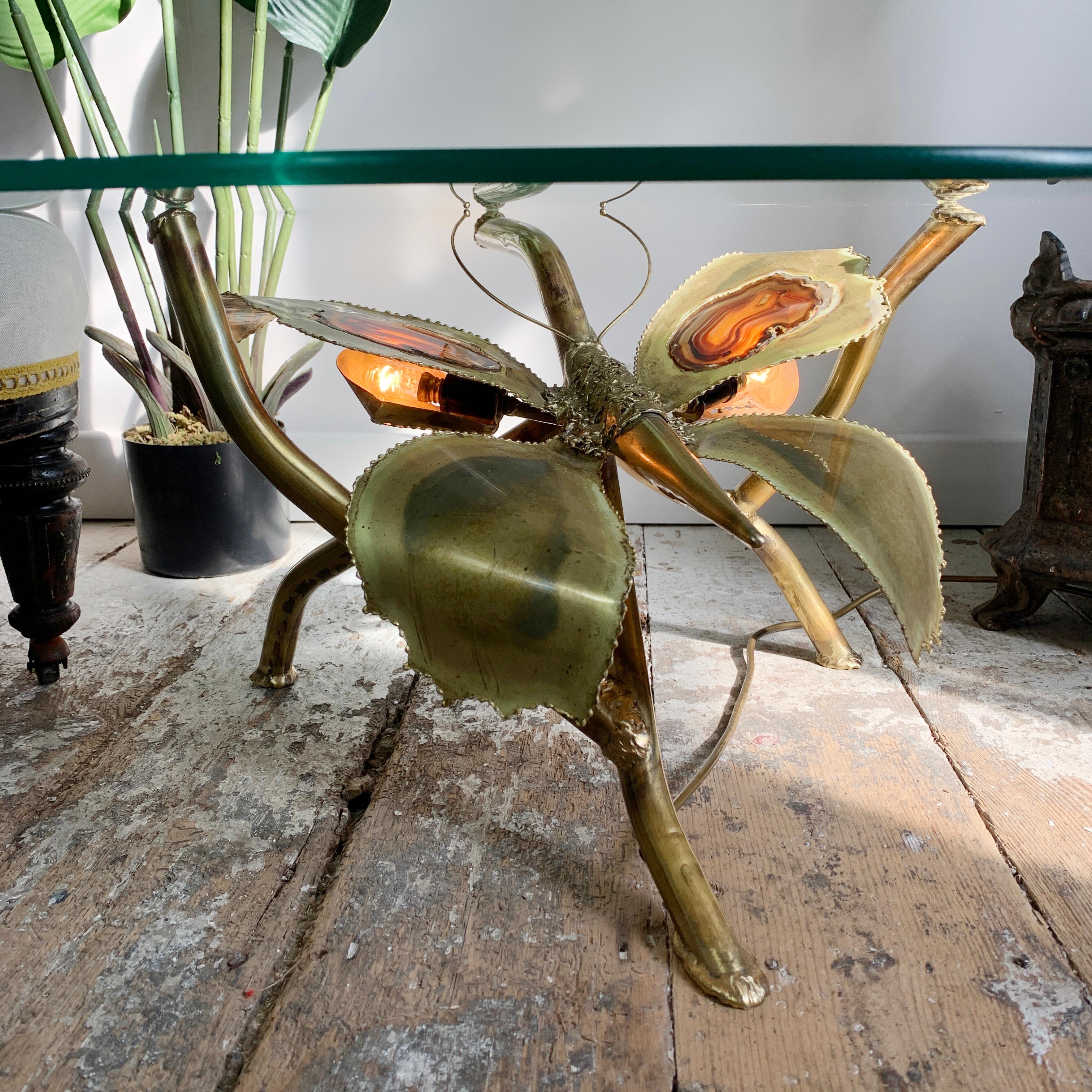 Une magnifique table basse artisanale inspirée des papillons, conçue et fabriquée par l'artiste et sculpteur de renommée mondiale Jacques Duval Brasseur dans les années 1970. Le superbe corps en laiton est incrusté de deux tranches de pierre