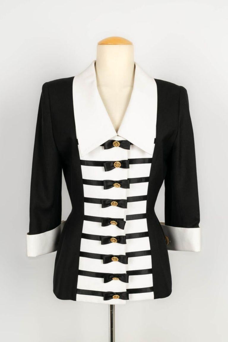 Jacques Fath - Jacket in black canvas and white cotton piqué with satin ribbons forming small bows. No size indicated, it corresponds to a 38FR. 
To note, presence of stains.

Additional information: 

Dimensions: Shoulder width: 44 cm, Chest: 46