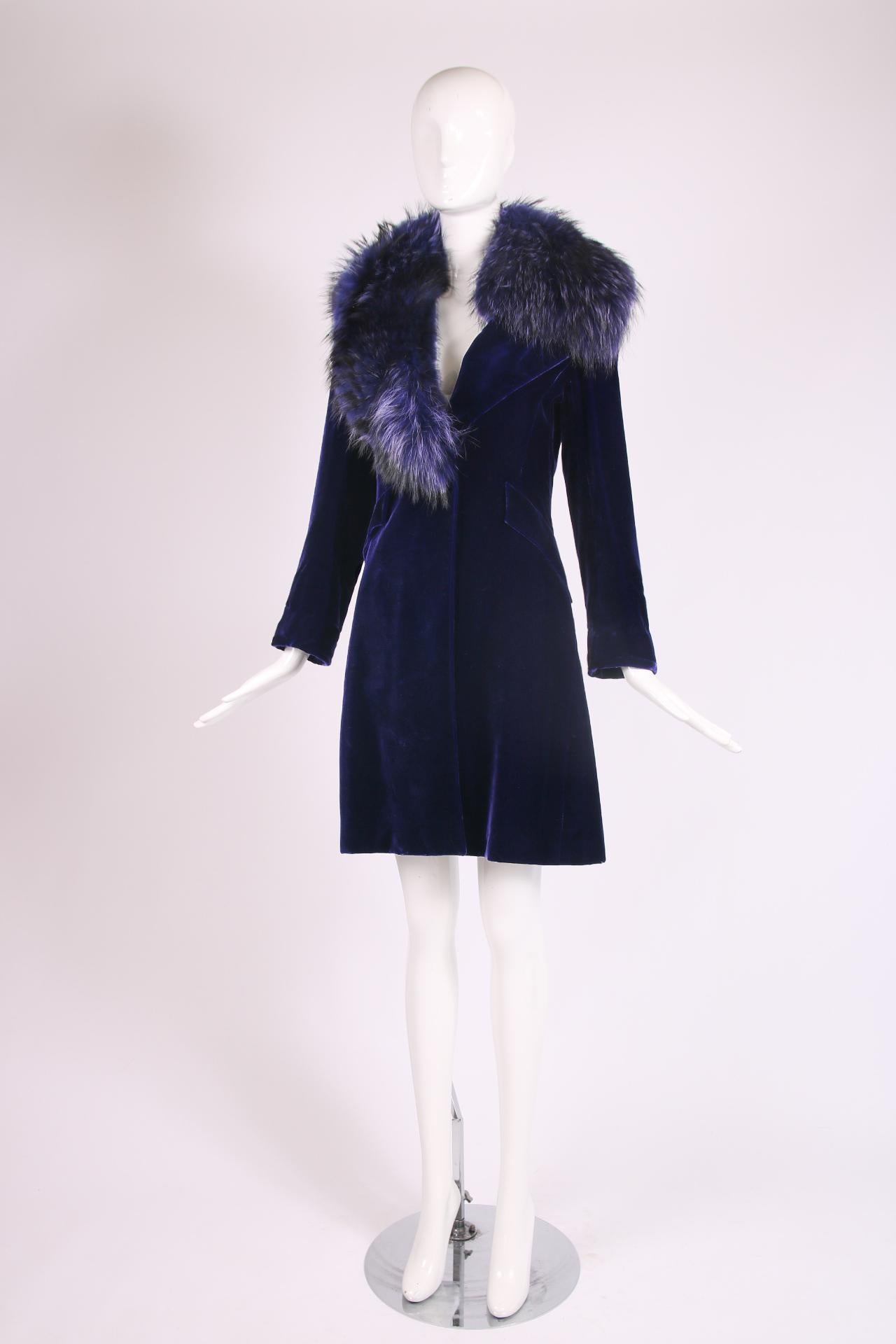 Jacques Fath purple velvet coat with a purple fur collar, single silvertone button closure, faux frontal pockets and two vents at the back. Size 38. In very good condition with some small, scattered marks to the velvet. Please see