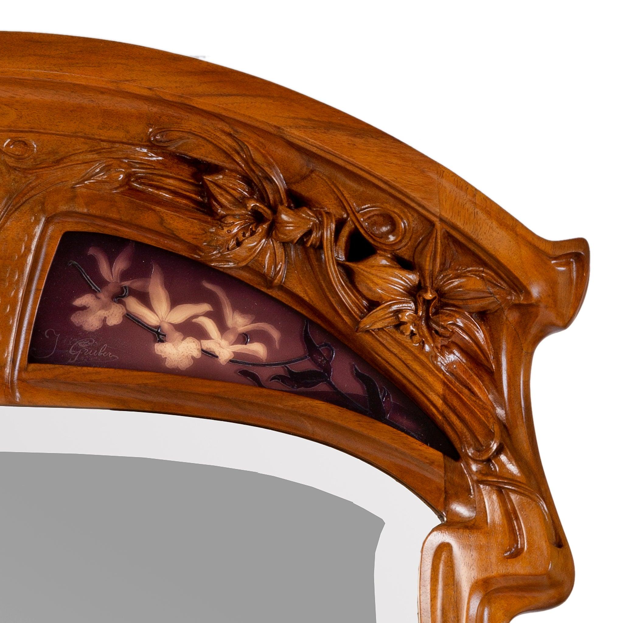 This Jacques Gruber aux orchidée mirror features carved walnut Phaius orchids and inset burgundy cameo glass panels of Oncidium orchids. The popularity of orchids with European audiences had grown dramatically in the fin de siecle, as new colonial