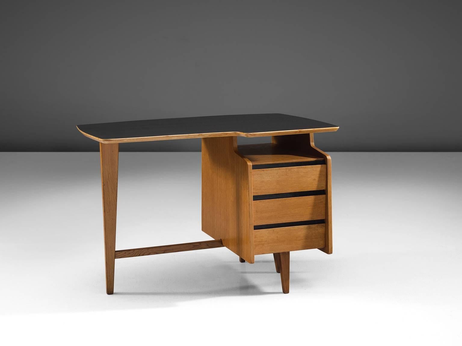 Jacques Hauville for Bema, desk, oak, Formica, France, 1960s.

This desk was designed by Jacques Hauville for Bema in the circa 1960. It has a mahogany structure with four tapered legs connected with a strut. The desk is asymmetrical and has only