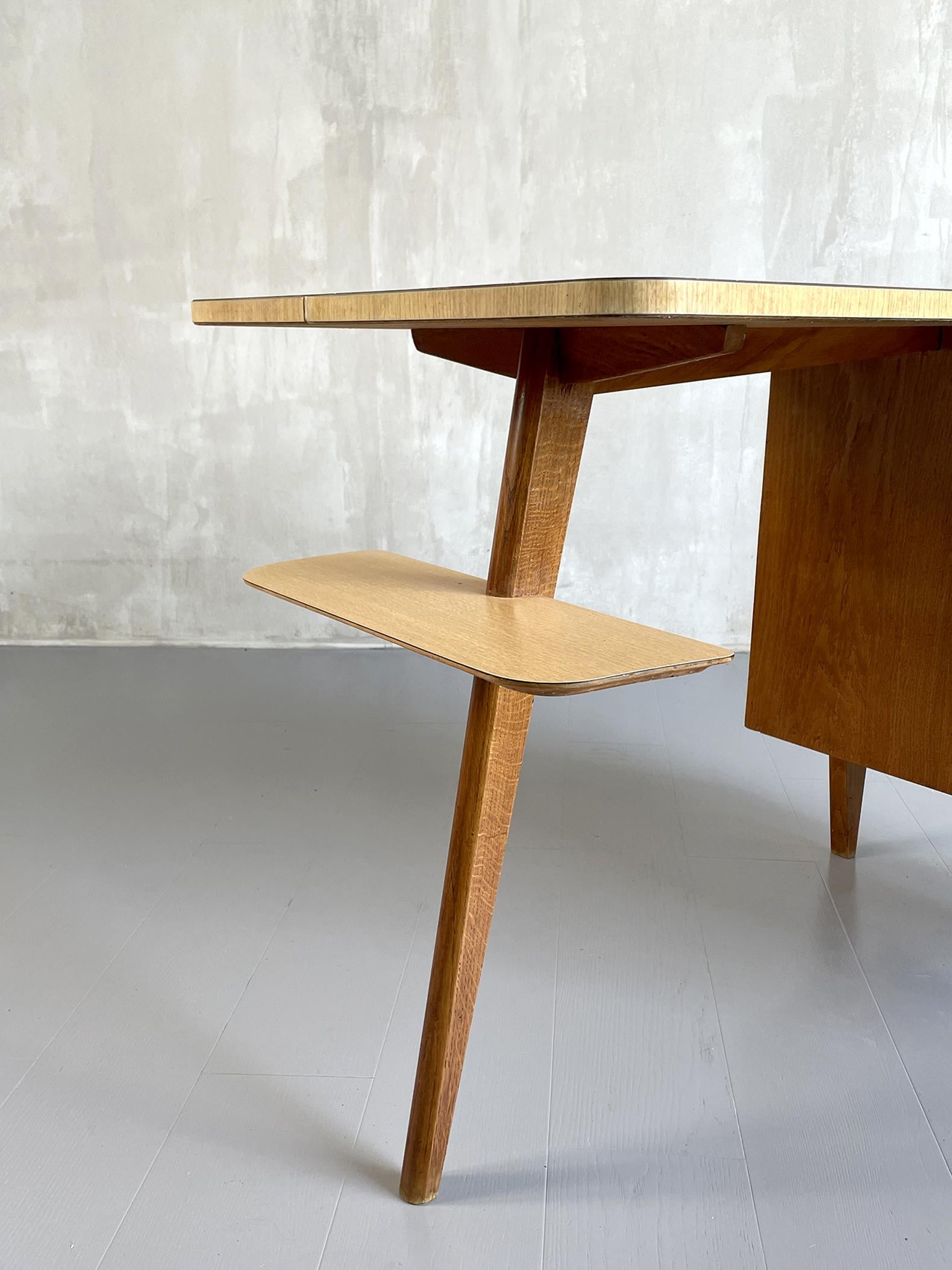 Tripod desk in blond oak and satin formica by Jacques Hauville, France 1950. A box with three drawers is placed on the right, a housing is located under the top. A profiled shelf is attached to the left leg.