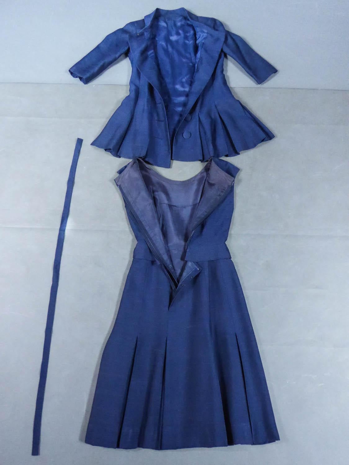 Circa 1956
France

Set of day dress and jacket Jacques Heim in navy blue wool around 1956. Very close to the flared line A of Christian Dior, superposition of the box folds of the jacket on the box folds of the skirt, amplifying the conical effect