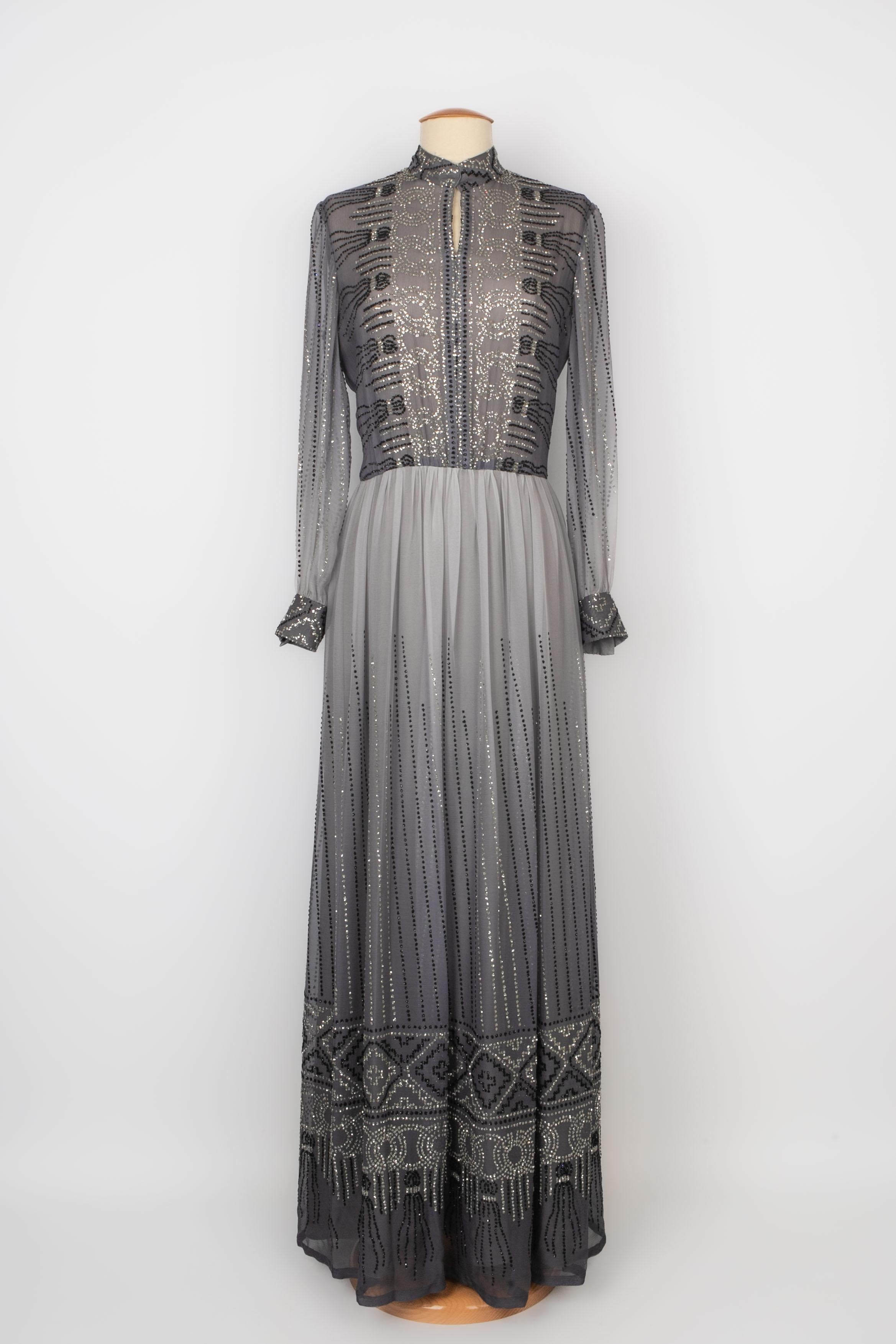 JACQUES HEIM - (Made in France) Long muslin dress in grey tones and entirely sewn with black and silvery sequins. Missing size and composition labels, it fits a 38FR.

Condition:
Very good condition

Dimensions:
Shoulder width: 39 cm - Sleeve
