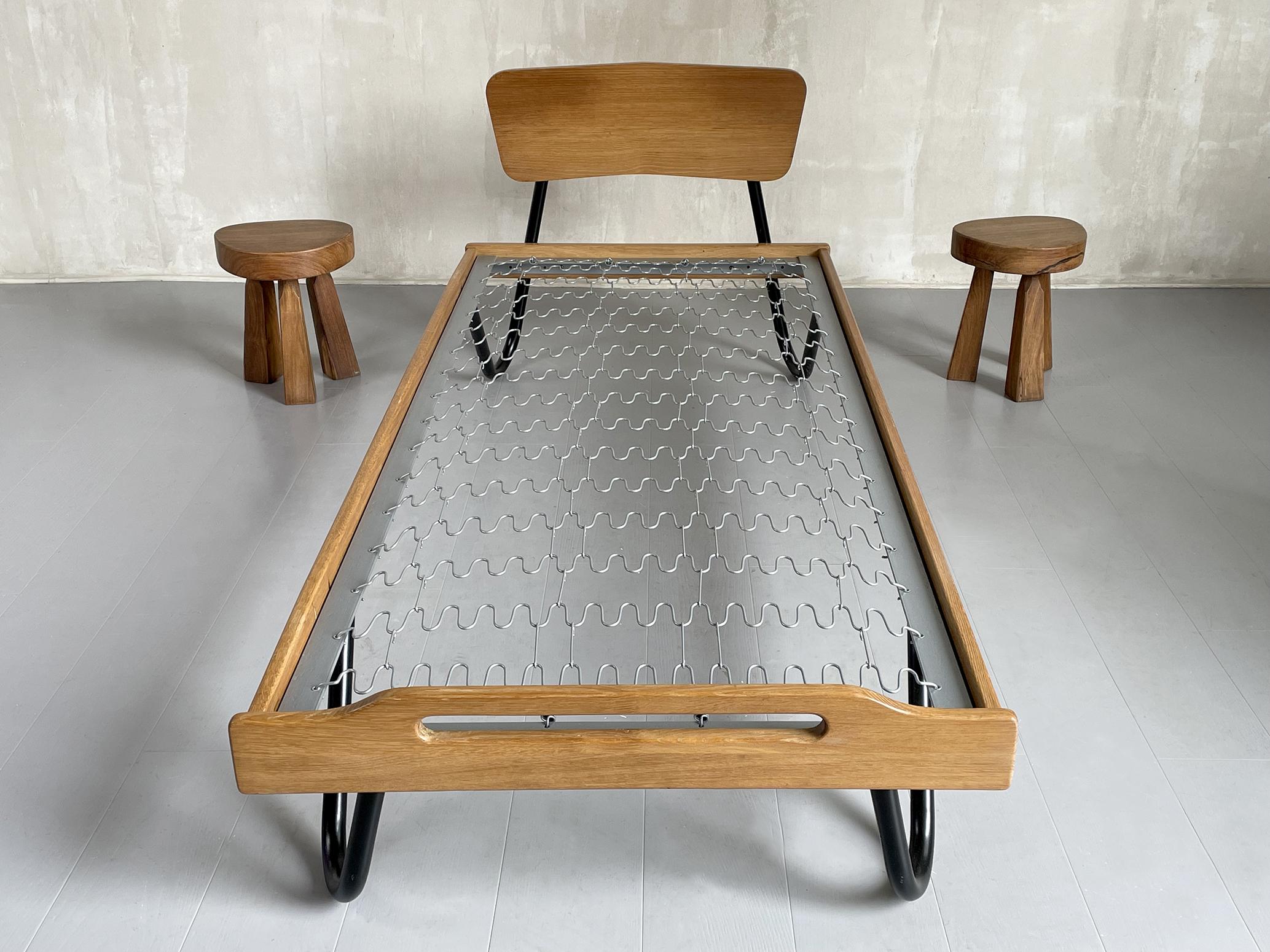 Daybed in blond solid oak and black lacquered tubular metal by Jacques Hitier, Tubauto edition, France 1950. The metal base is surrounded by an oak frame, the curved base receives the headboard and at the foot a profiled and hollowed out