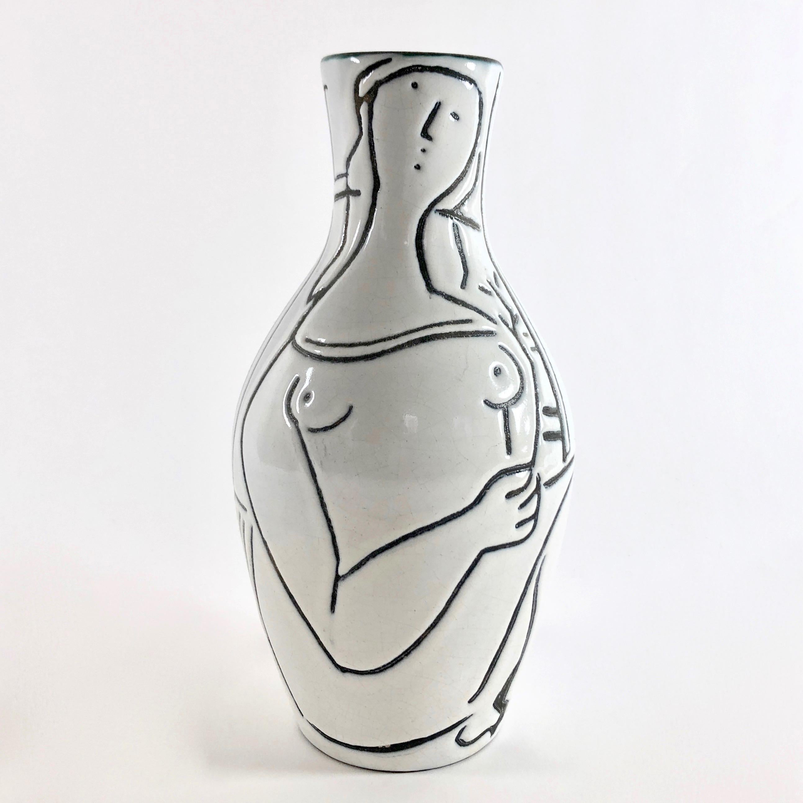 Ceramic vase, bottle shaped.
Vallauris red clay glazed in pure white and polychrome touches, decorated front and back with stylized female figures engraved in reserve on a black matte background.
A rare piece considering the dimensions. 

The