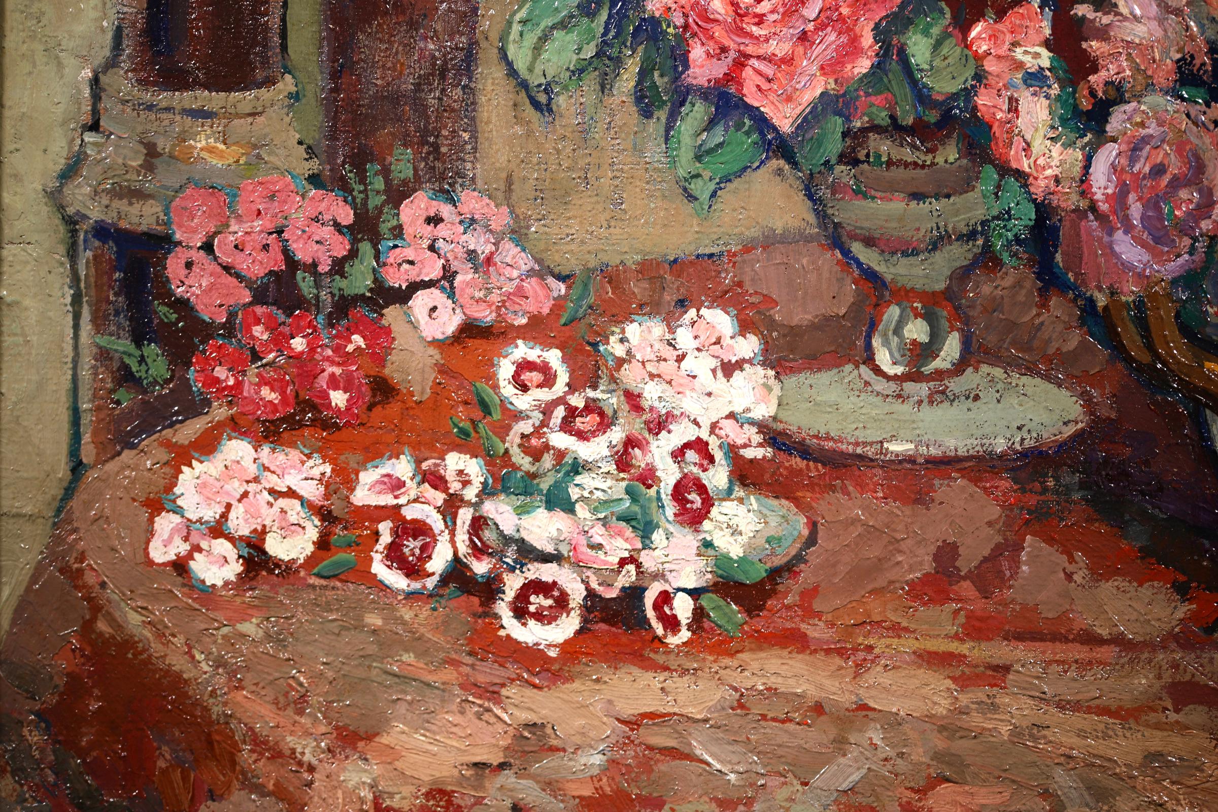 A superb oil on canvas circa 1925 by French Post-Impressionist painter Jacques Martin-Ferrieres. The piece depicts vases of beautiful flowers of pinks, reds and yellows placed on a dresser. An image of the room can be seen reflected in the mirror.