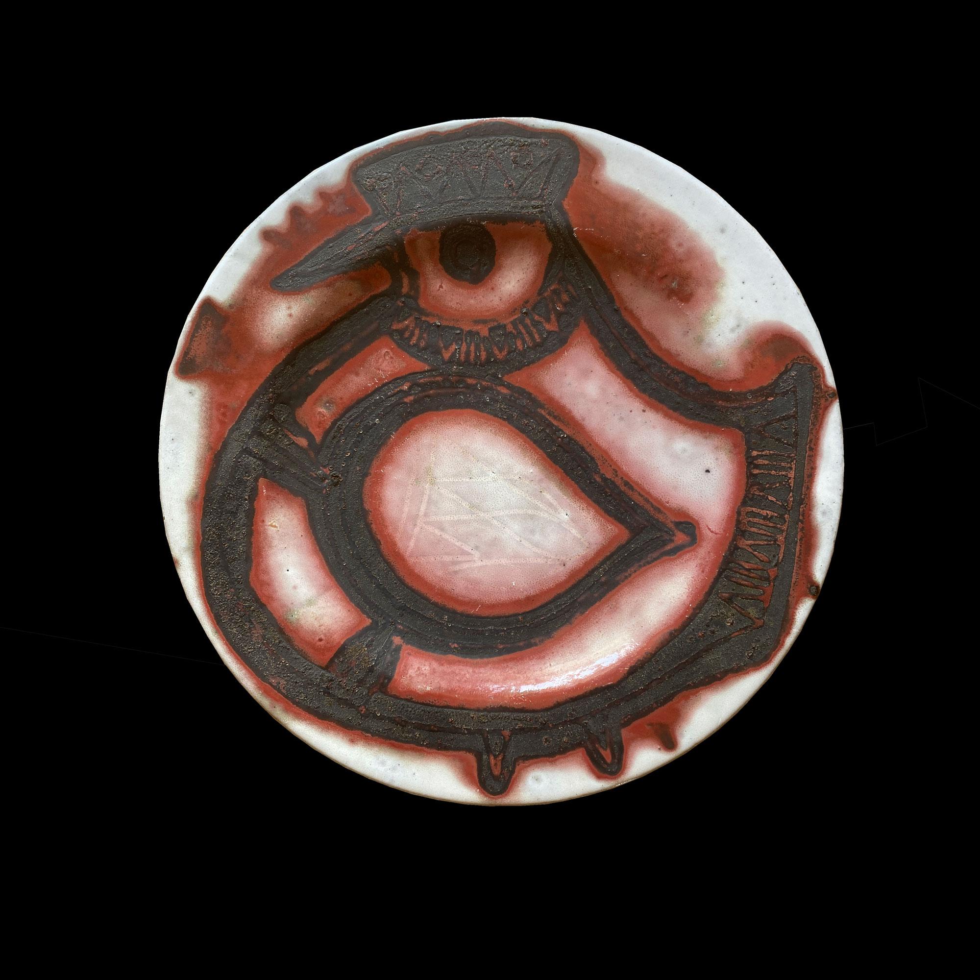 JACQUES POUCHAIN ​​(1925-2005) 
LARGE CIRCULAR DISH In white enamelled earthenware with reserved decoration of a stylized bird (chicken) in matt black on a red background. initial signature on the reverse of the piece Diam. 49.5cm