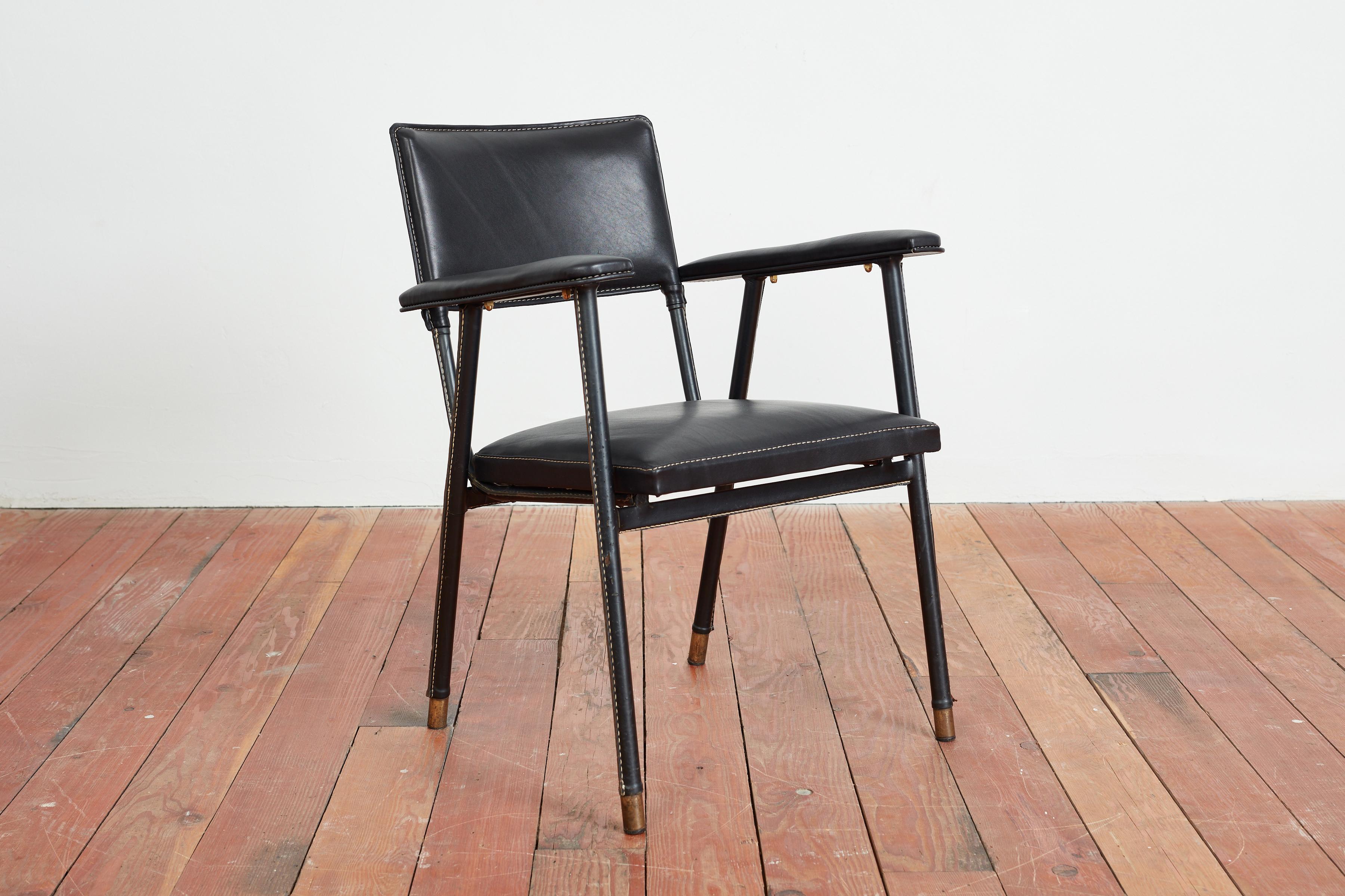 Jacques Quinet arm chair in black leather with signature contrast hand stitching and thick brass feet.
Wonderful angled legs and patina to leather on legs. 
Seat newly upholstered in France. 
France, 1950s
