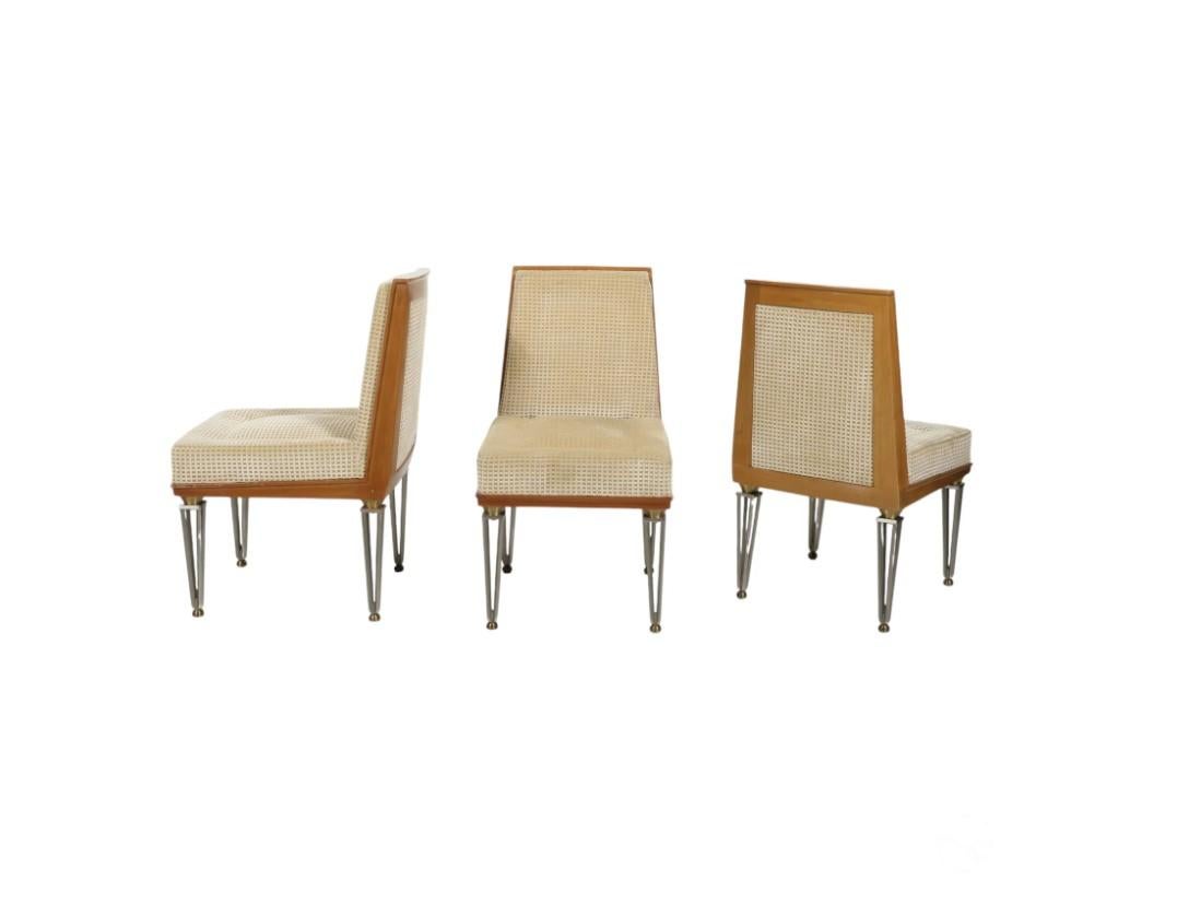 Un set di 12 sedie da pranzo moderne francesi di Jacques Quinet. Le sedie presentano una struttura in legno di ciliegio con gambe in acciaio traforato cromato opaco, accentuate da sfere in ottone. I sedili imbottiti di colore beige chiaro sono
