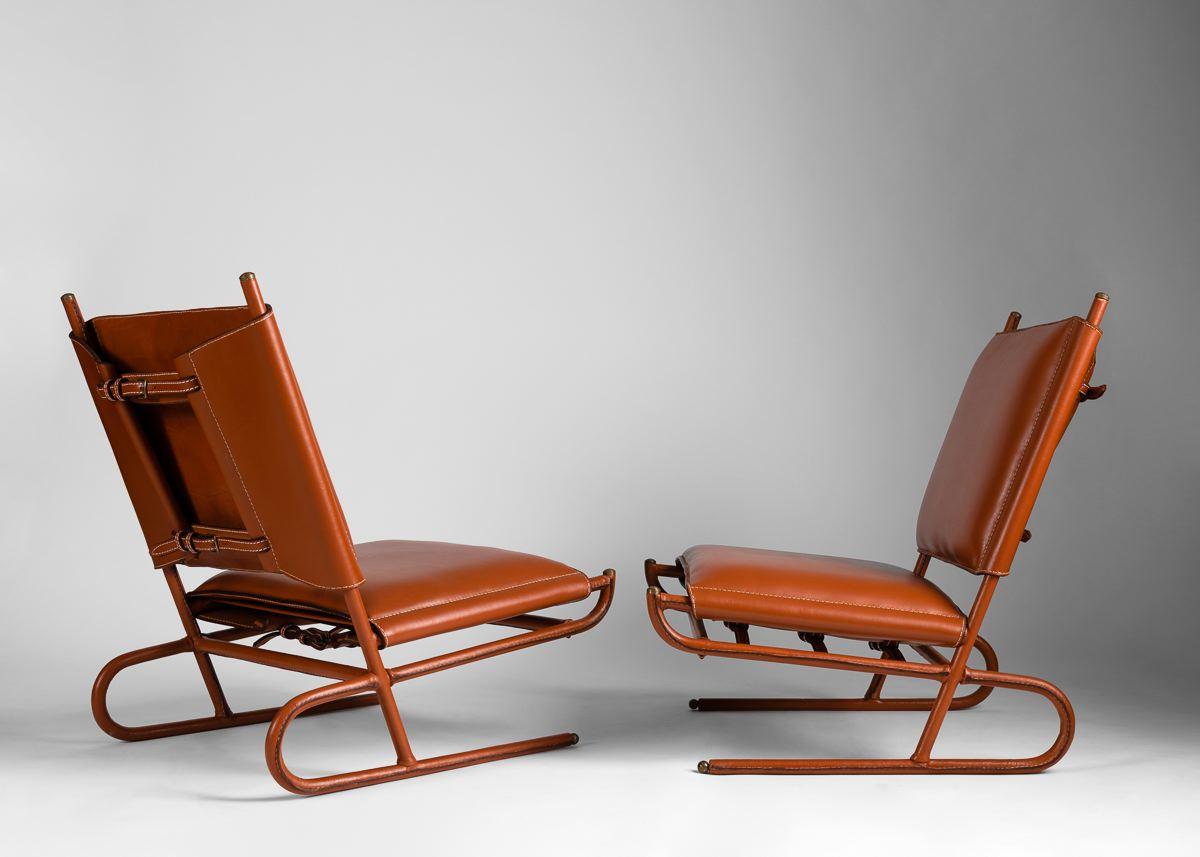 This extraordinary pair of lounge chairs are an excellent examples Quinet's midcentury output, and feature strapped backs, metal sabots, and lush, newly restored skai upholstery.