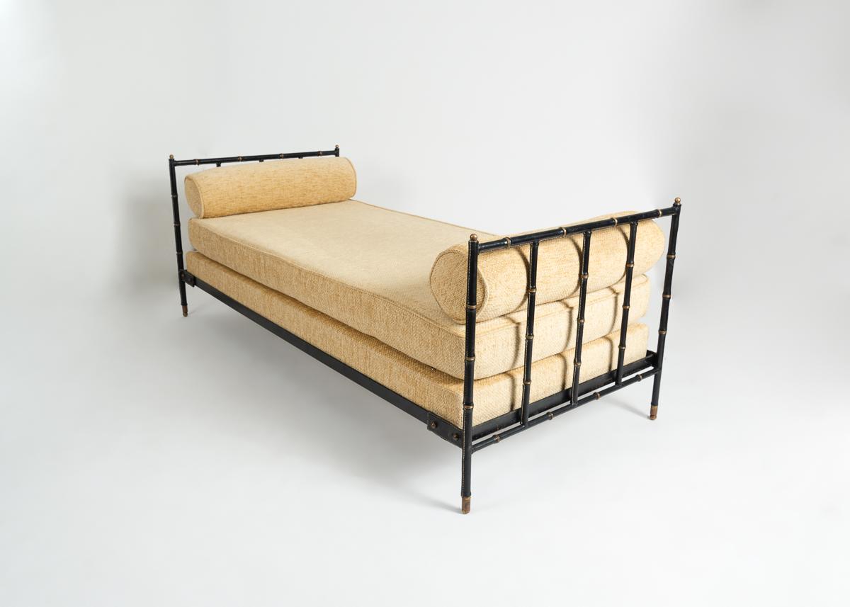 A work of marvelous symmetry, this plush daybed is book-ended by barred head-and-footrests executed in the French designer's signature brass and saddle-stitched leather framing.