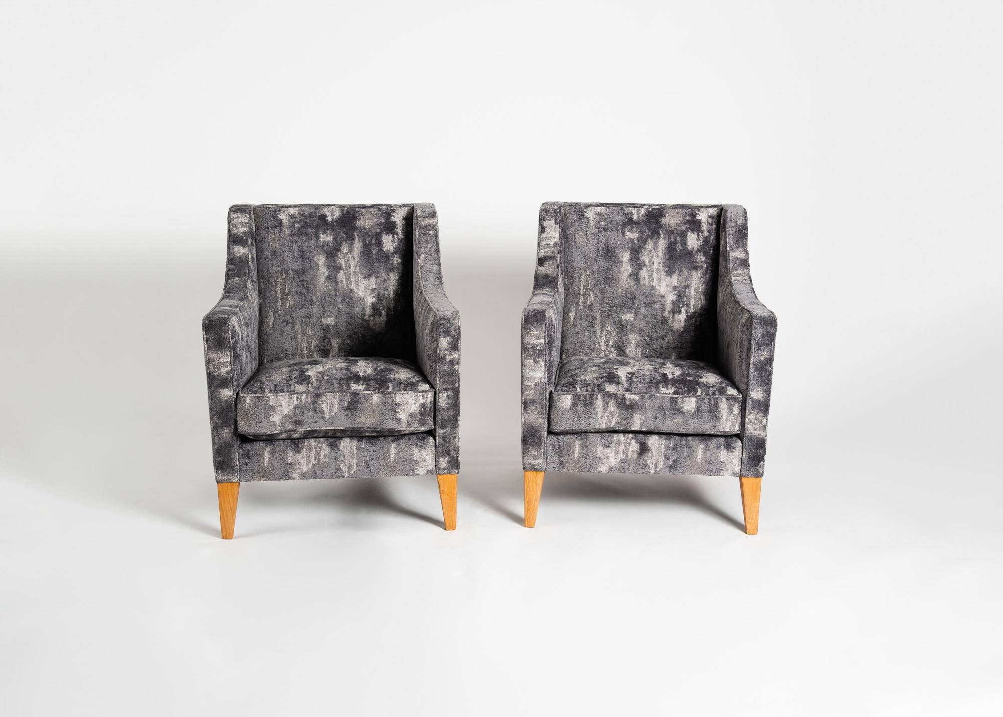 Œuvre typique du milieu du siècle français, cette paire de fauteuils du maître Jacques Quinet présente des éléments identifiables de son style, les arêtes carrées, les pieds légèrement effilés et la sensibilité géométrique.