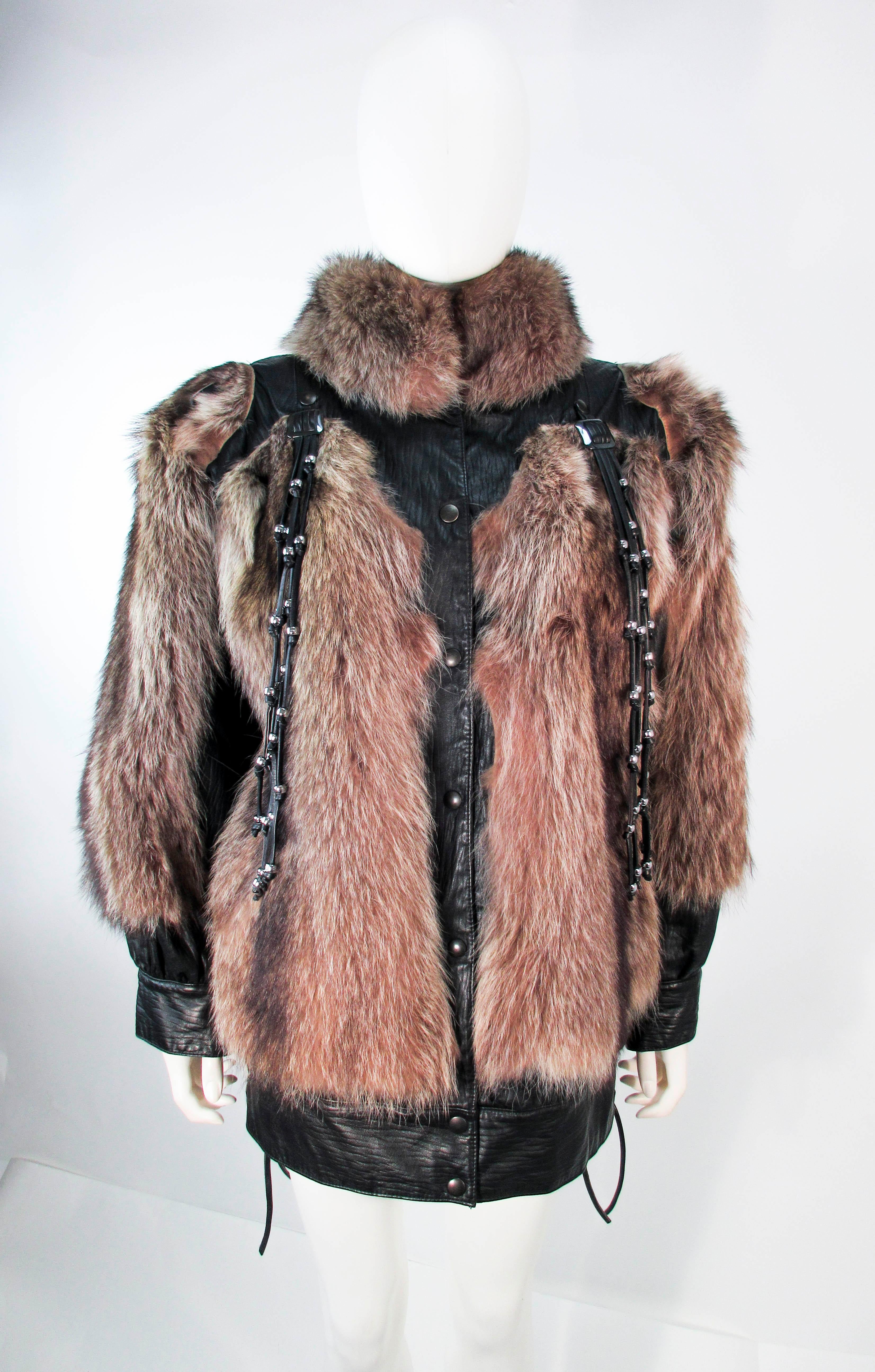 This is an amazing Jacques Saint Laurent jacket which is composed of raccoon fur with leather trim. Features detachable leather tassels and a side tie lace up corset detail at the waist. There are pockets and center front snap closures. In excellent