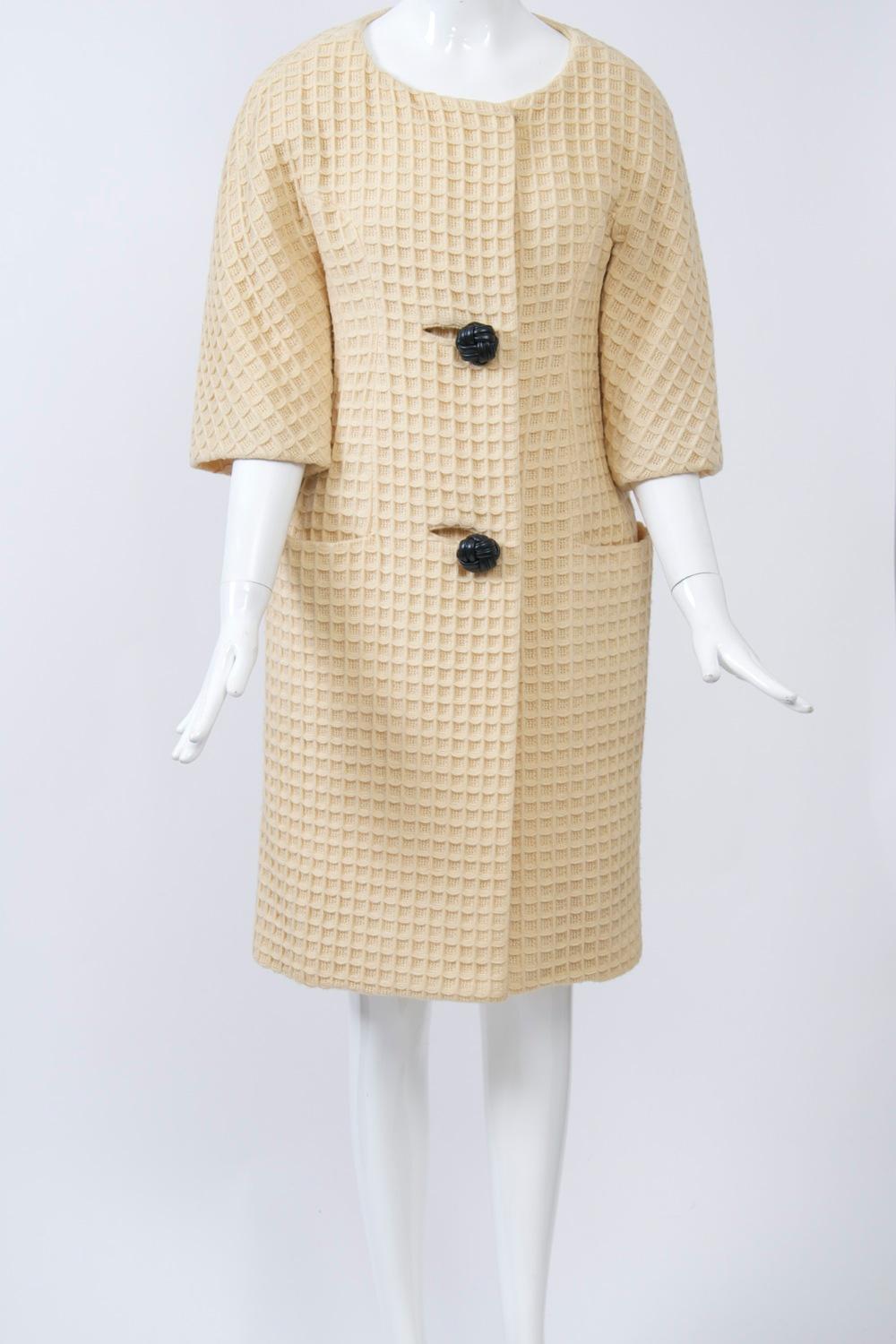 This iconic 1960s coat was designed by Jacques Tiffeau, a transplanted French designer who was extremely influential during the 1960s and was the recipient of two Coty awards. He was particularly admired for his coat designs that were spare and
