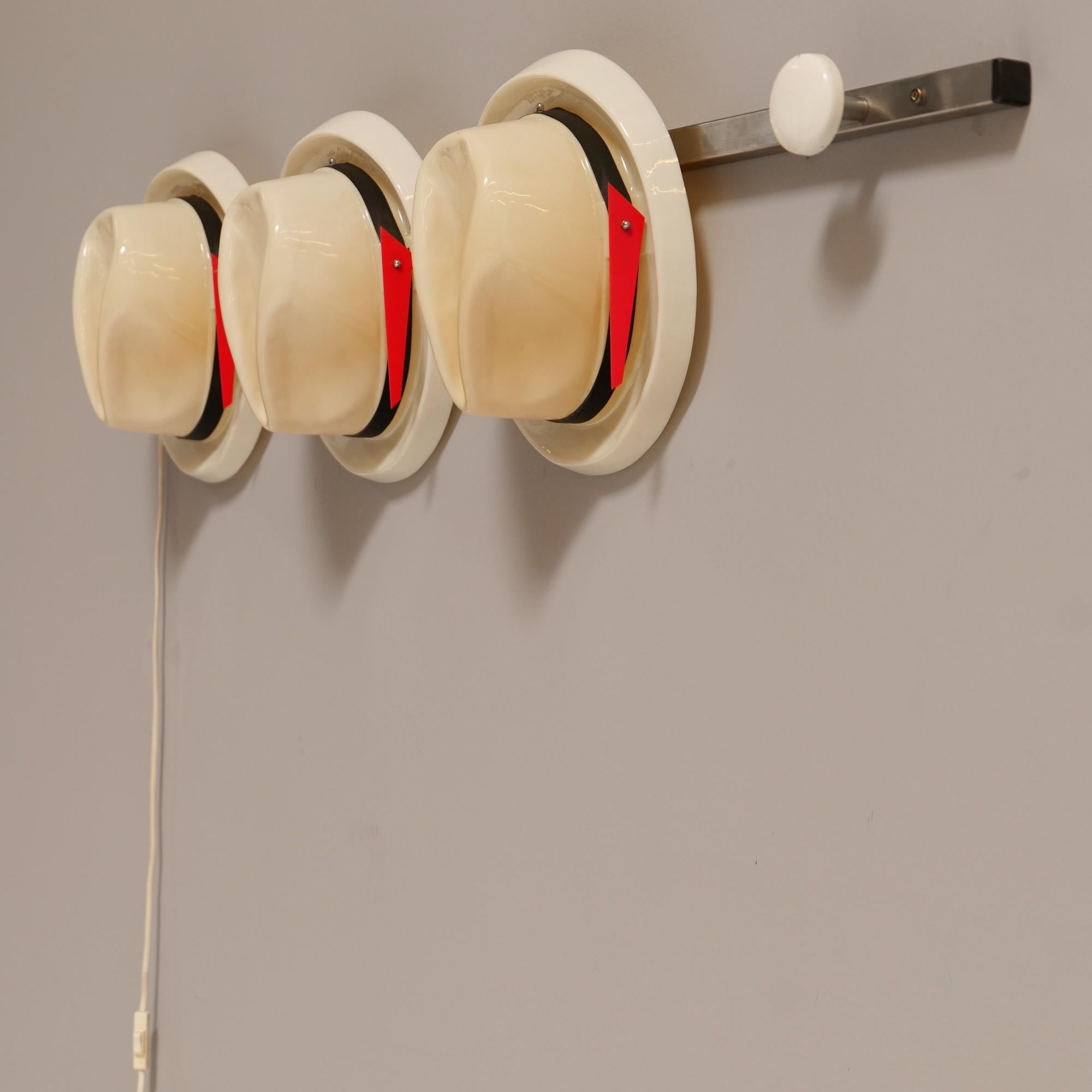 Jacques Vojnovic, light object from the film adaptation of the book “IT” by Steven King, 1990.

This is a light art object probably by Jacques Vojnovic.

It consists of three hats and a dress button, mounted on a metal rod.

The hats are made