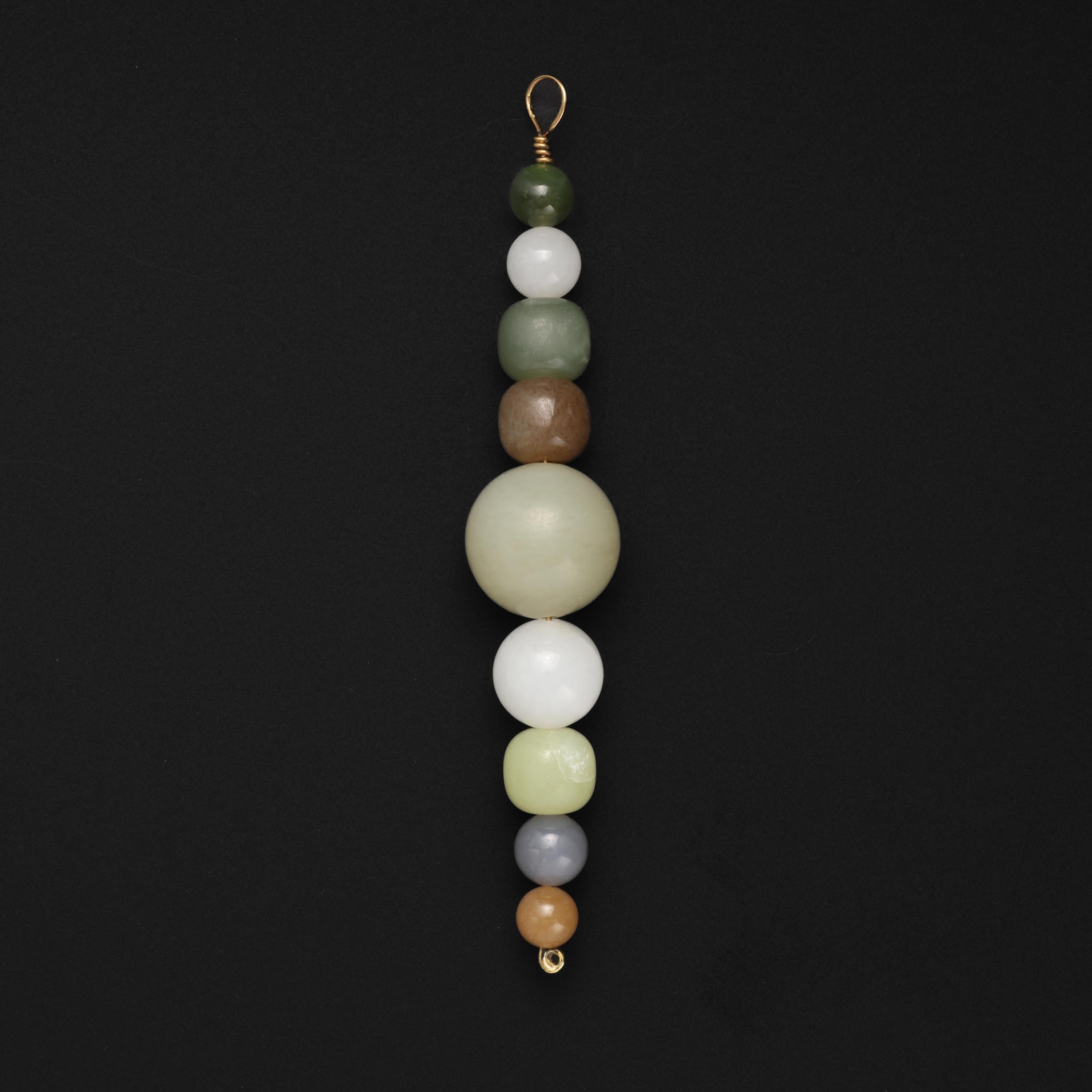 This simple, classic, fully modern pendant features a simple solid 22K wire along which are strung 9 jade beads that range in size from 8.02mm to 19.92mm. These are the nephrite variety of jade -as opposed to Jadeite. Nephrite has been the