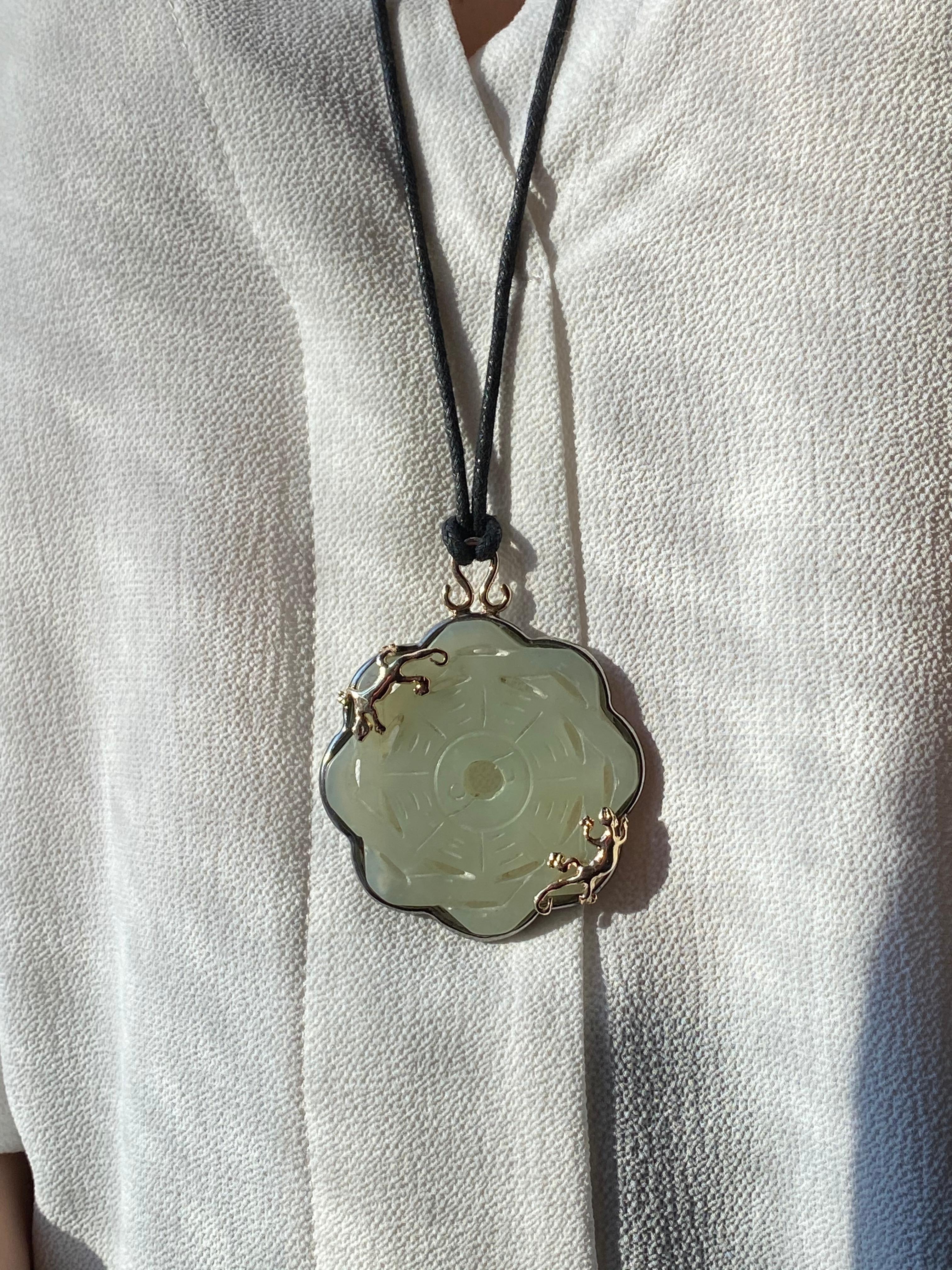 Rossella Ugolini Design Collection One-of-a Kind Carved Green Jade Handarbeit in 24K Gelbgold-Plated Silver Sterling und verziert mit zwei dynamischen und Lucky Geckos. 
Der Jade-Halsketten-Anhänger wird an einer gewachsten schwarzen Seidenschnur