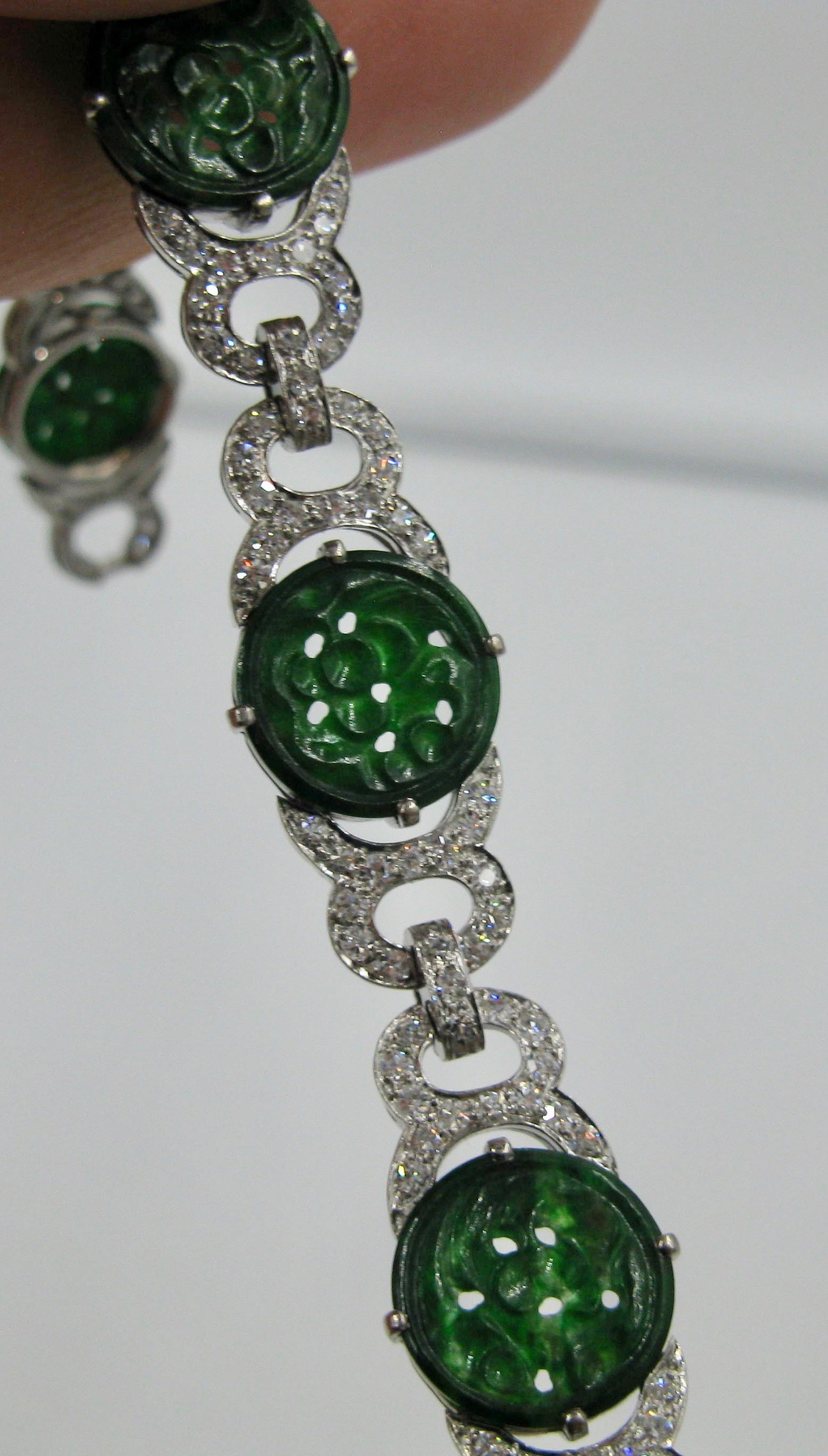 A spectacular bracelet with six round carved Jadeite medallions set with 174 sparkling white diamonds totaling 3.4 Carats.   The jewels are set in an open work Art Deco style link bracelet of Platinum over 18 Karat white gold!  This is one of the