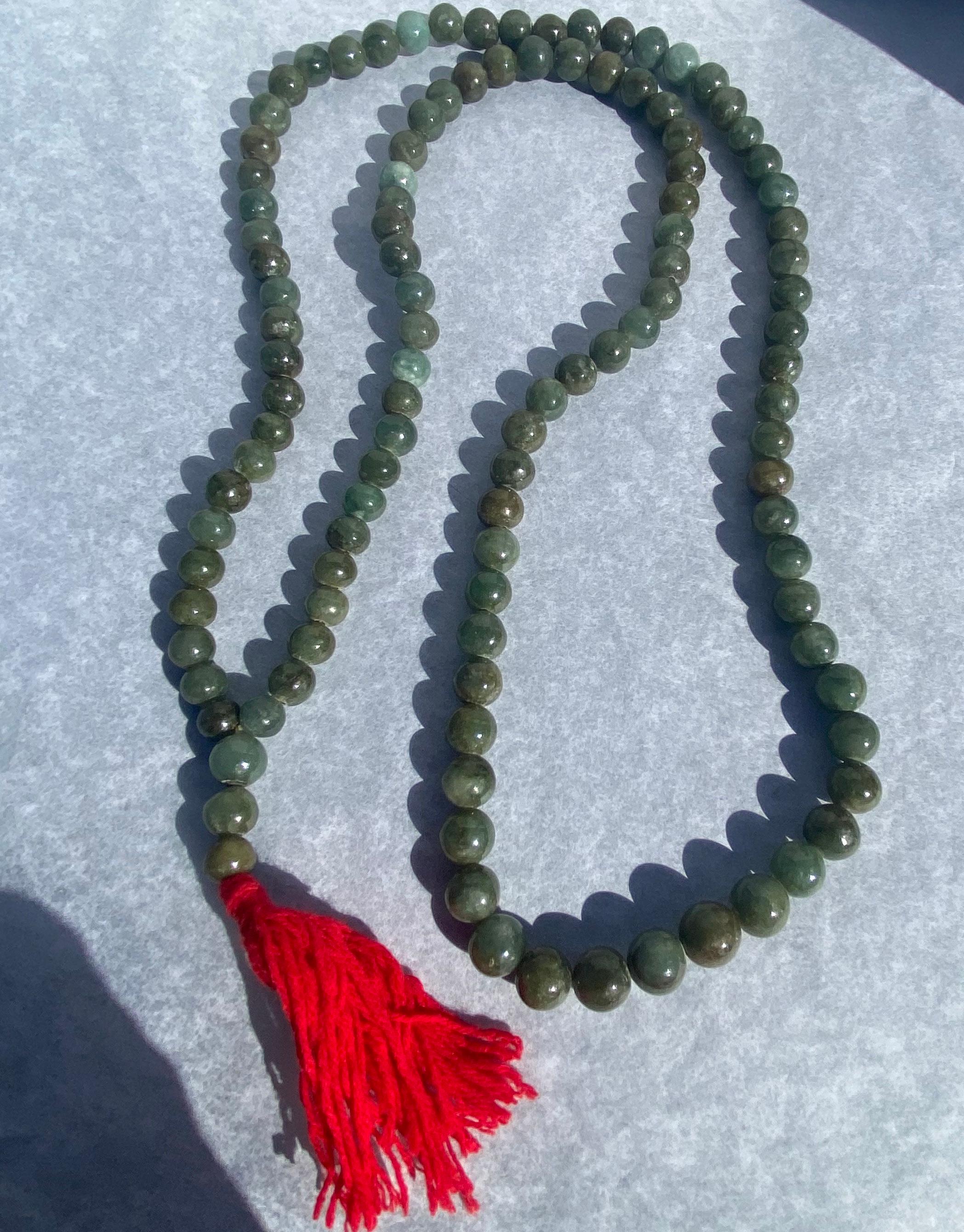Multi-colored green jade is strung on a long 40