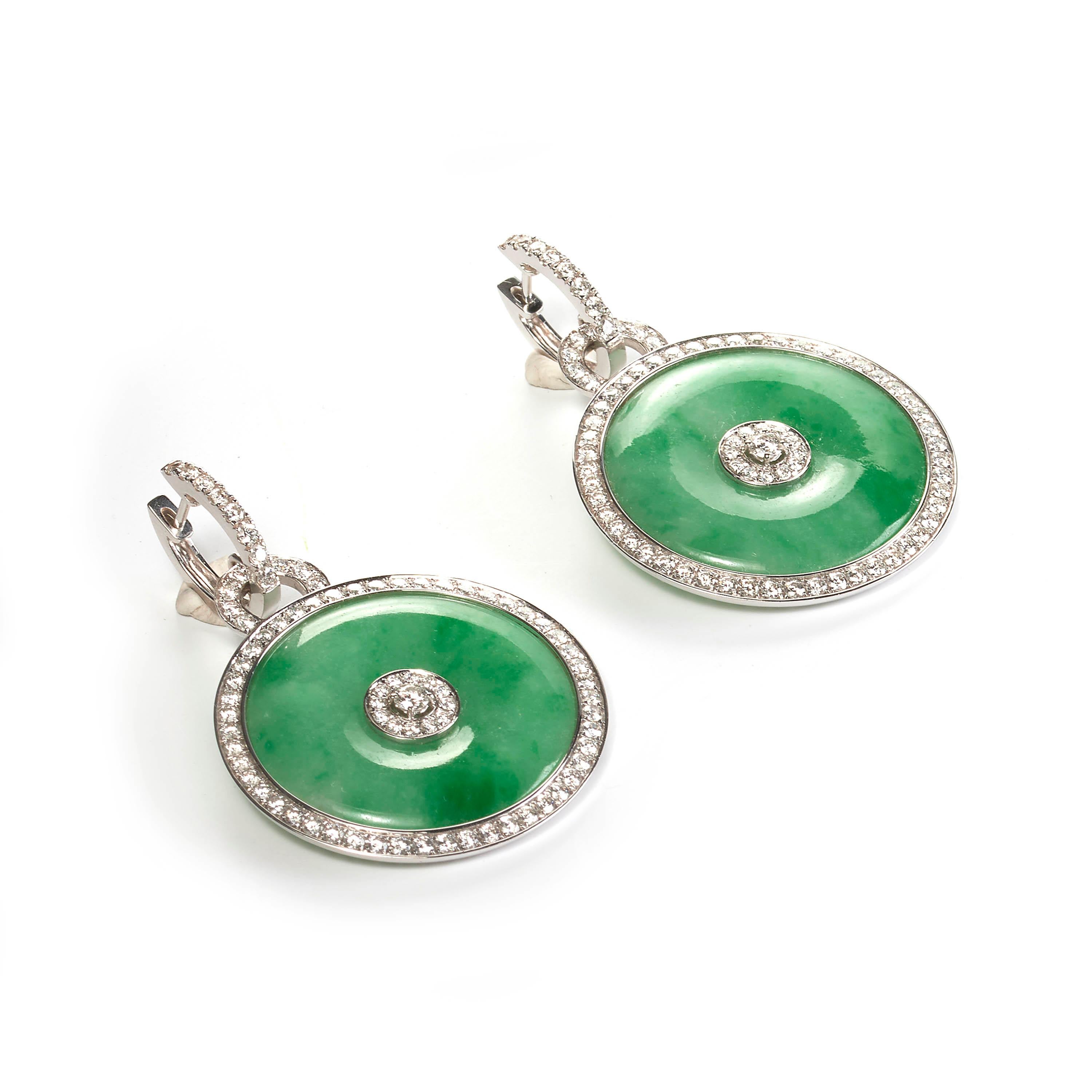 A pair of modern jade and diamond drop earrings, comprised of circular discs of polished green jade, with a round cluster of brilliant-cut diamonds in the centre, further surrounded by a border of diamonds, and diamond-set hoop fittings, all mounted