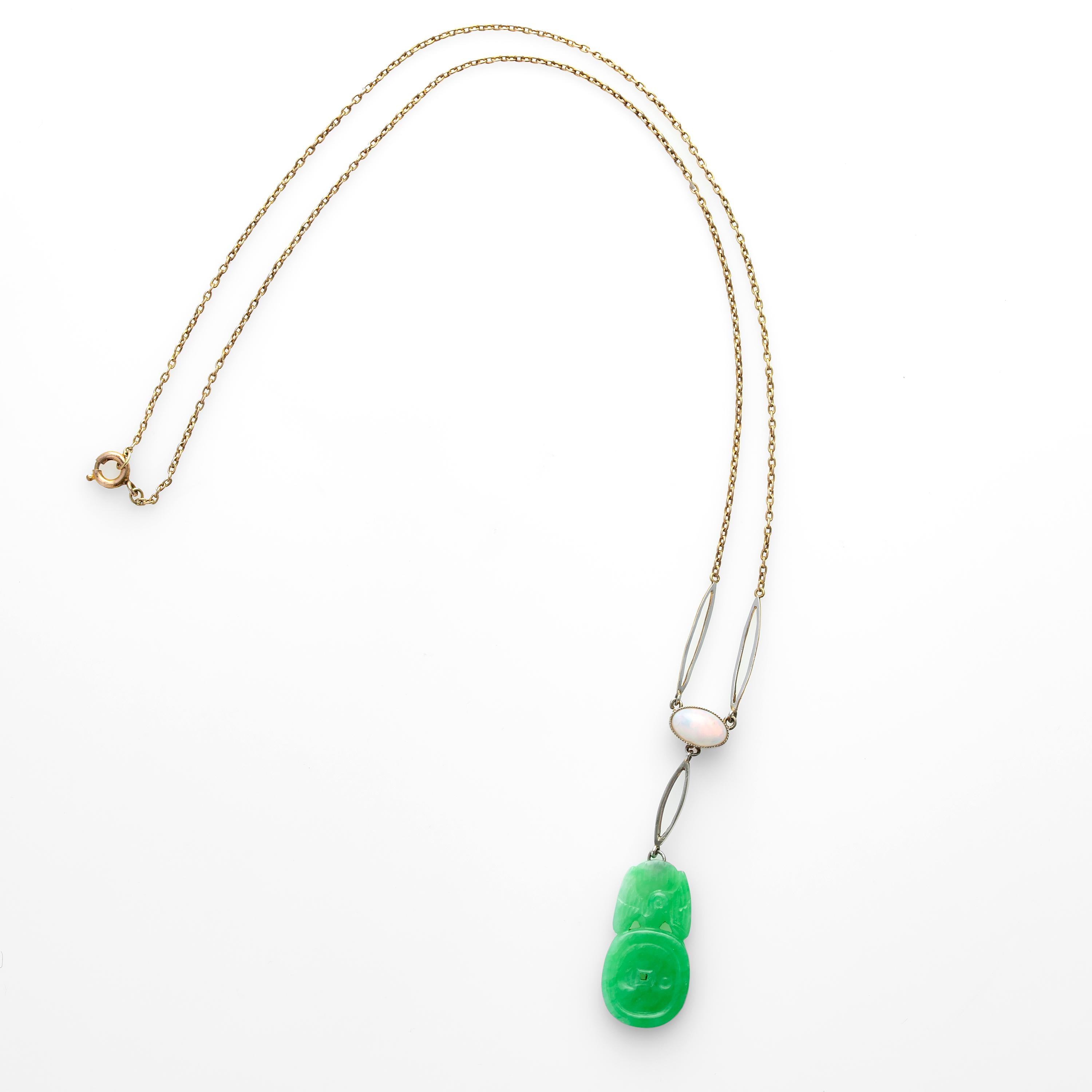 This light, bright, and unusual Edwardian-era necklace features a natural, firey Australian opal from which is suspended a certified natural and untreated jadeite jade carving of a bat perched atop a coin; a visual pun based on the pronunciation of