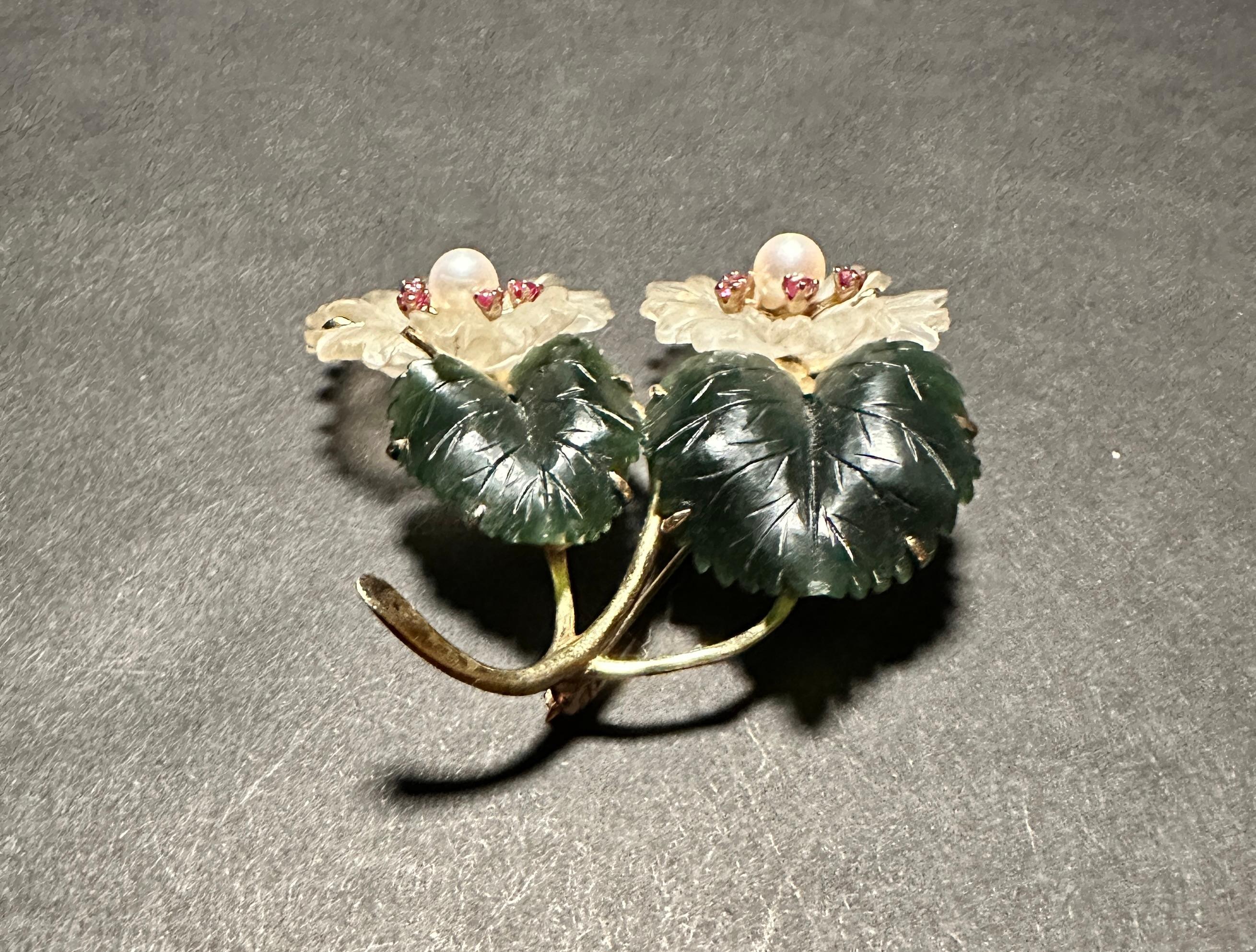 14 karat yellow gold floral form carved Jade and rock crystal pin brooch with two pearls and 10 rubies. Carved jade leaves and rock crystal flowers with pearls and rubies set in center.