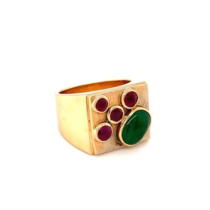One green jade and ruby 18K yellow gold ring featuring one bezel set, oval cabochon jade stone as well as 4 bezel set, round rubies weighing approximately 1 ct. in total. With heavily textured and high polish mount.

Chunky, colorful,