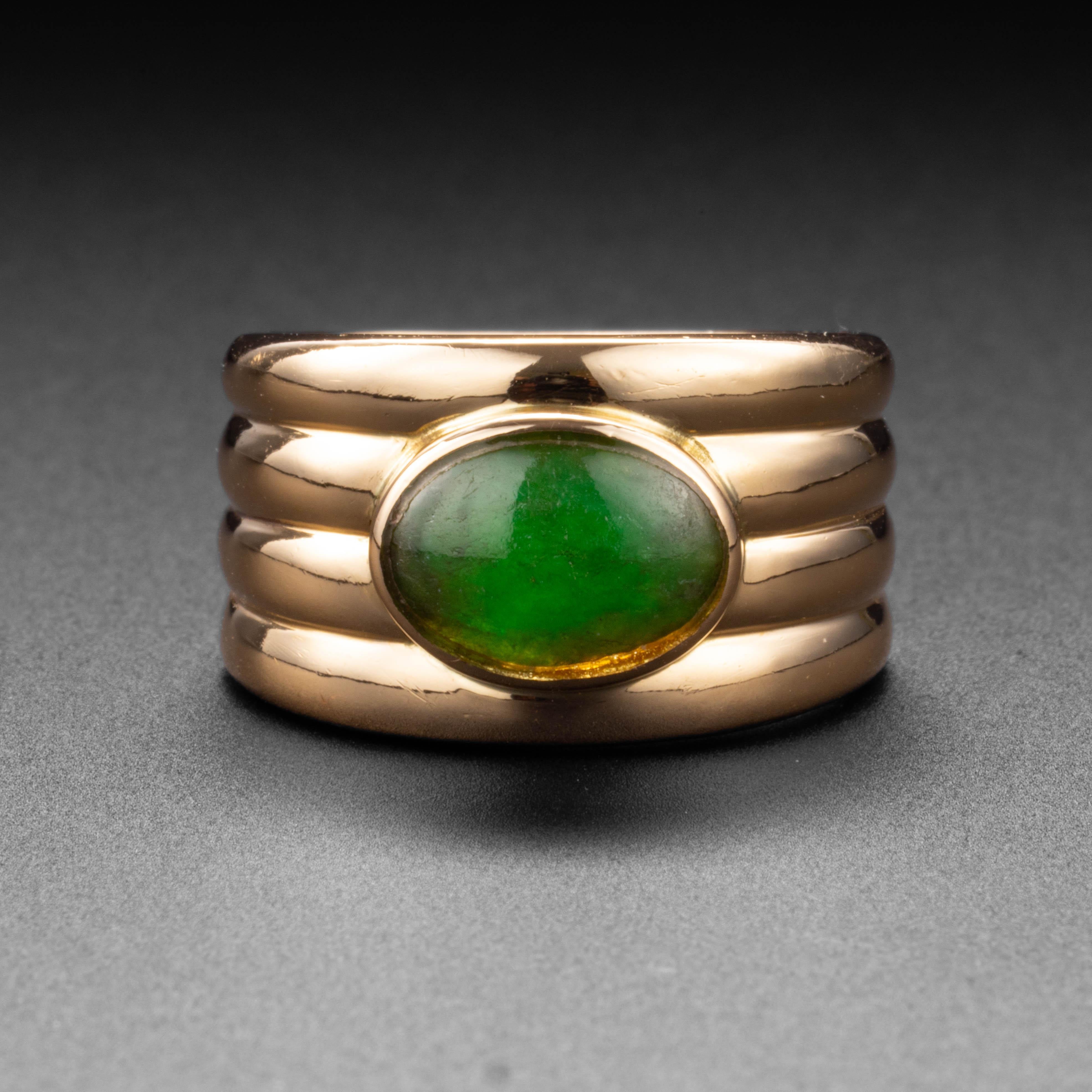 This mint-condition early Mid-century 14K yellow gold band ring features a 10.6 x 7.7mm cabochon of natural, untreated Burmese jadeite jade. The ring was created by Ming's of Hawaii; an iconic Hawaiian jeweler who created magnificent and unusual