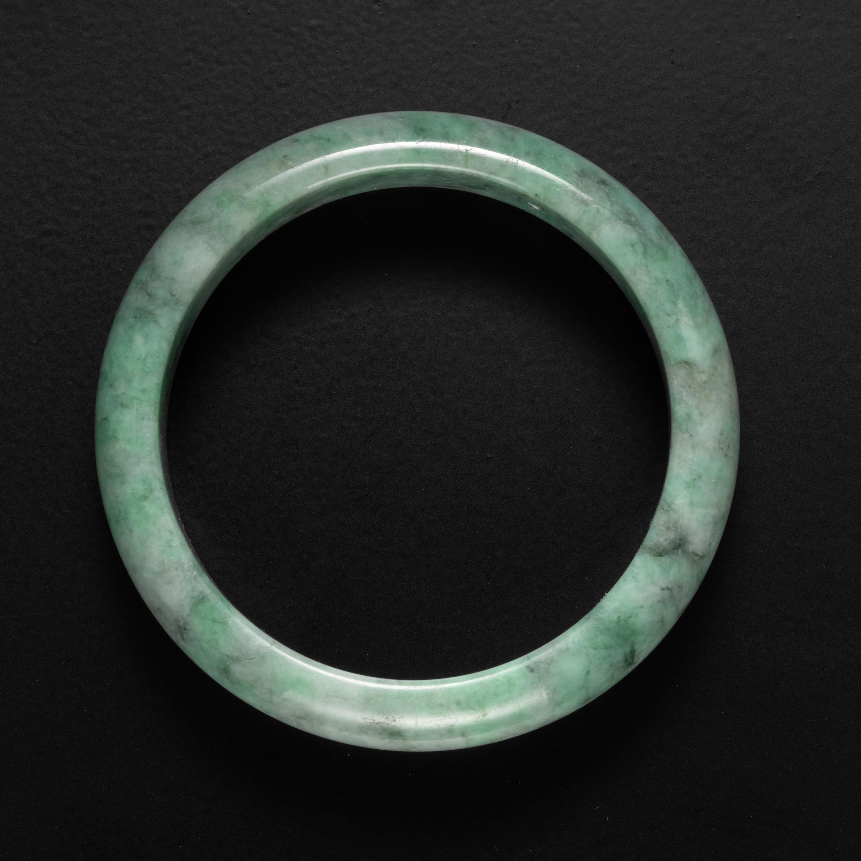 This gorgeous natural and untreated Burmese jadeite jade bangle is a lively mottled apple green. Free from dyes and polymers, this naturally beautiful bangle has an inner diameter of 55mm, meaning it will fit a small to medium wrist. The exterior