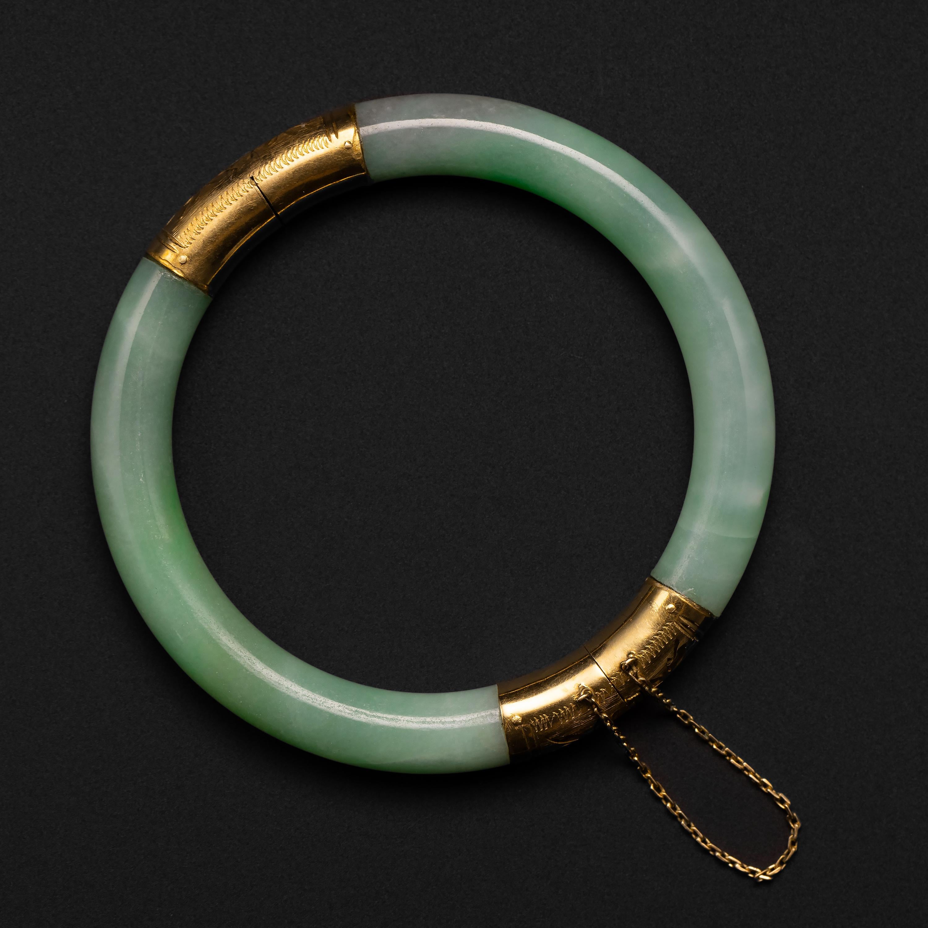 Dating to the Midcentury (circa 1970s), this bright apple green jadeite jade bangle is GIA certified to be natural and untreated. The interior diameter is approximately 56.76mm, but because the bangle is hinged, it will fit larger wrists. A hinged